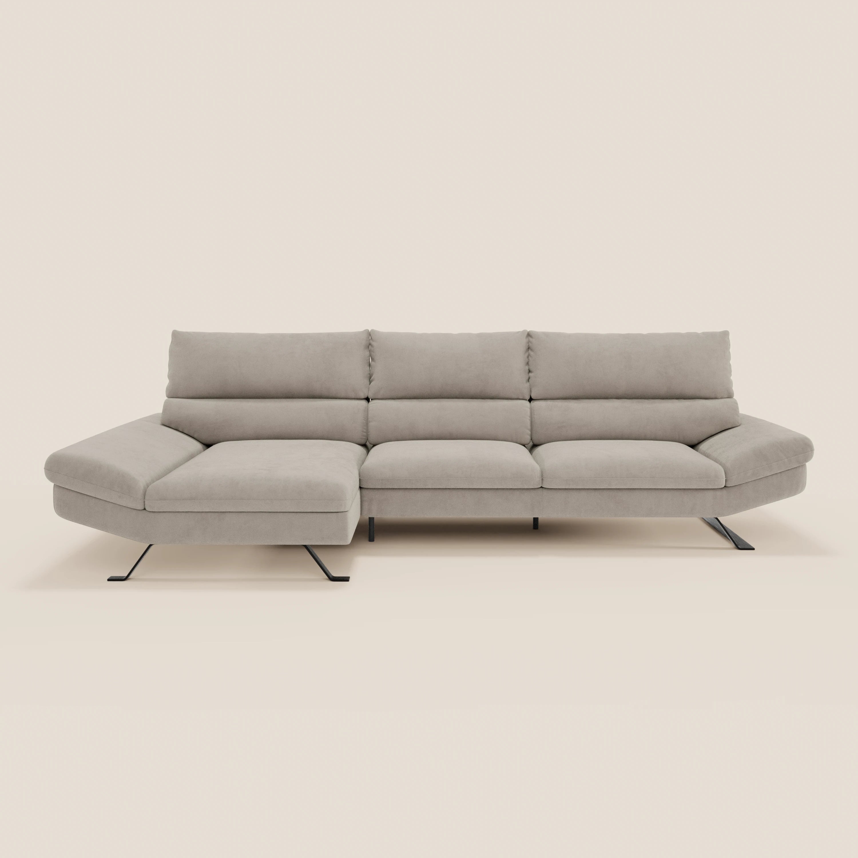 Il Divano Eclipse angolare con penisola e schienali traslanti T11 di Divani.Store è caratterizzato da un design moderno di colore grigio chiaro con tre sedute, una chaise longue sul lato sinistro, schienali regolabili e gambe sottili in metallo nero, su uno sfondo bianco sporco.