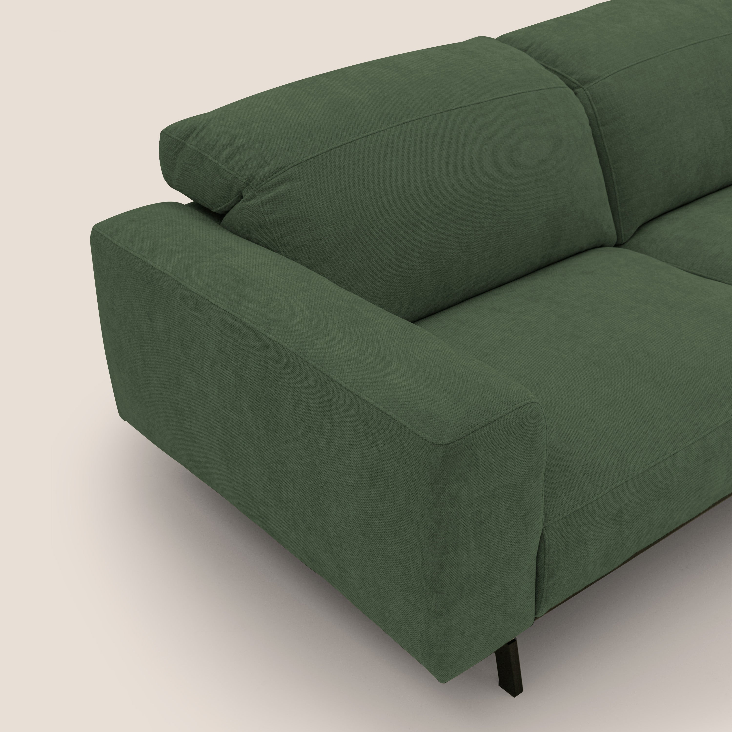 Primo piano del lato sinistro del divano Sakura di Divani.Store in piuma d'oca, un divano modulare a 3 posti rivestito in morbido tessuto fiammato verde T14 impermeabile, con ampi braccioli, cuscini in memory foam e gambe in metallo nero su sfondo beige.