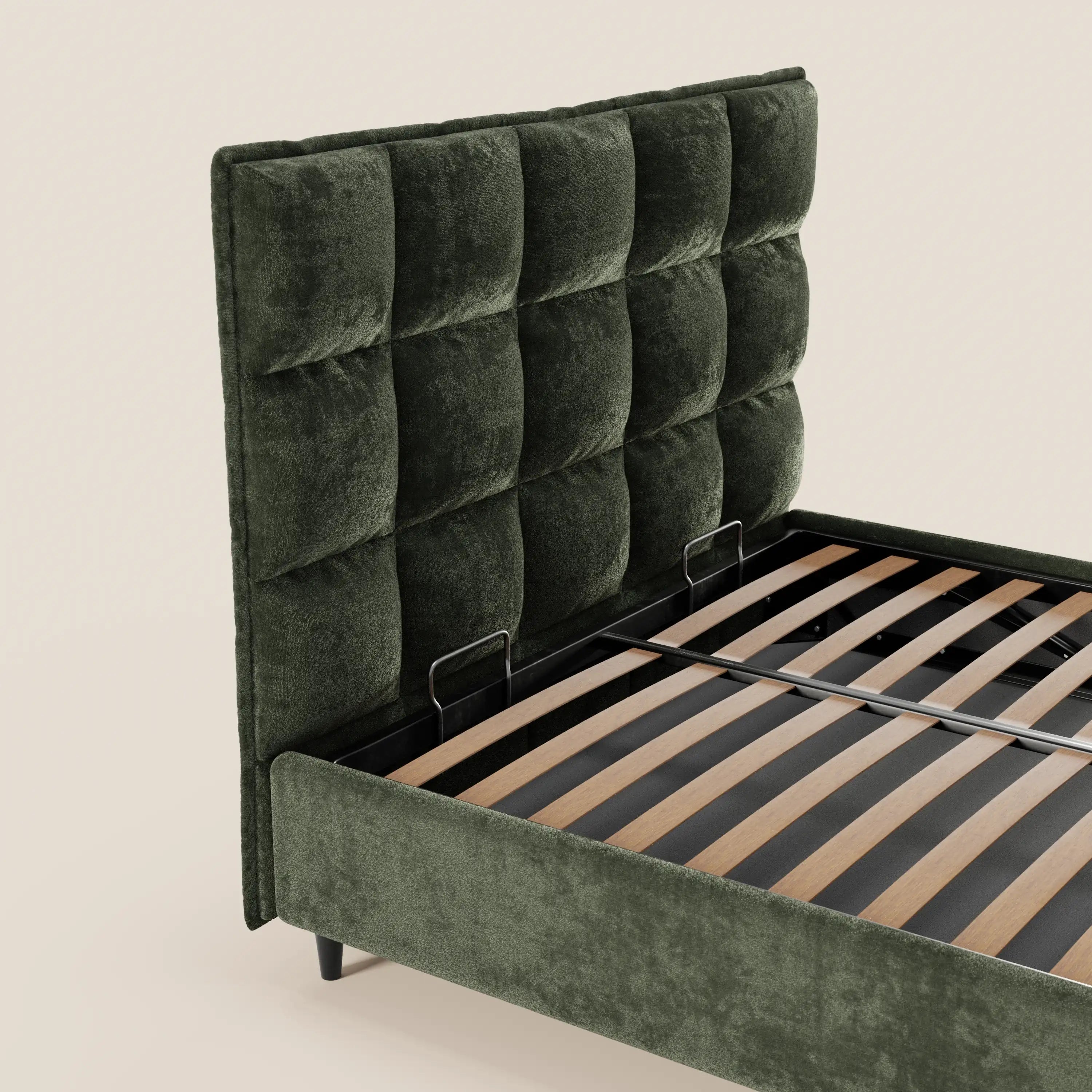 Il letto imbottito AURO di Letti.store presenta un rivestimento in ciniglia verde certificato Oeko-Tex®, una testiera alta capitonné, doghe in legno, supporti in metallo, gambe corte nere e un pratico vano contenitore. Il tutto su uno sfondo beige a tinta unita.