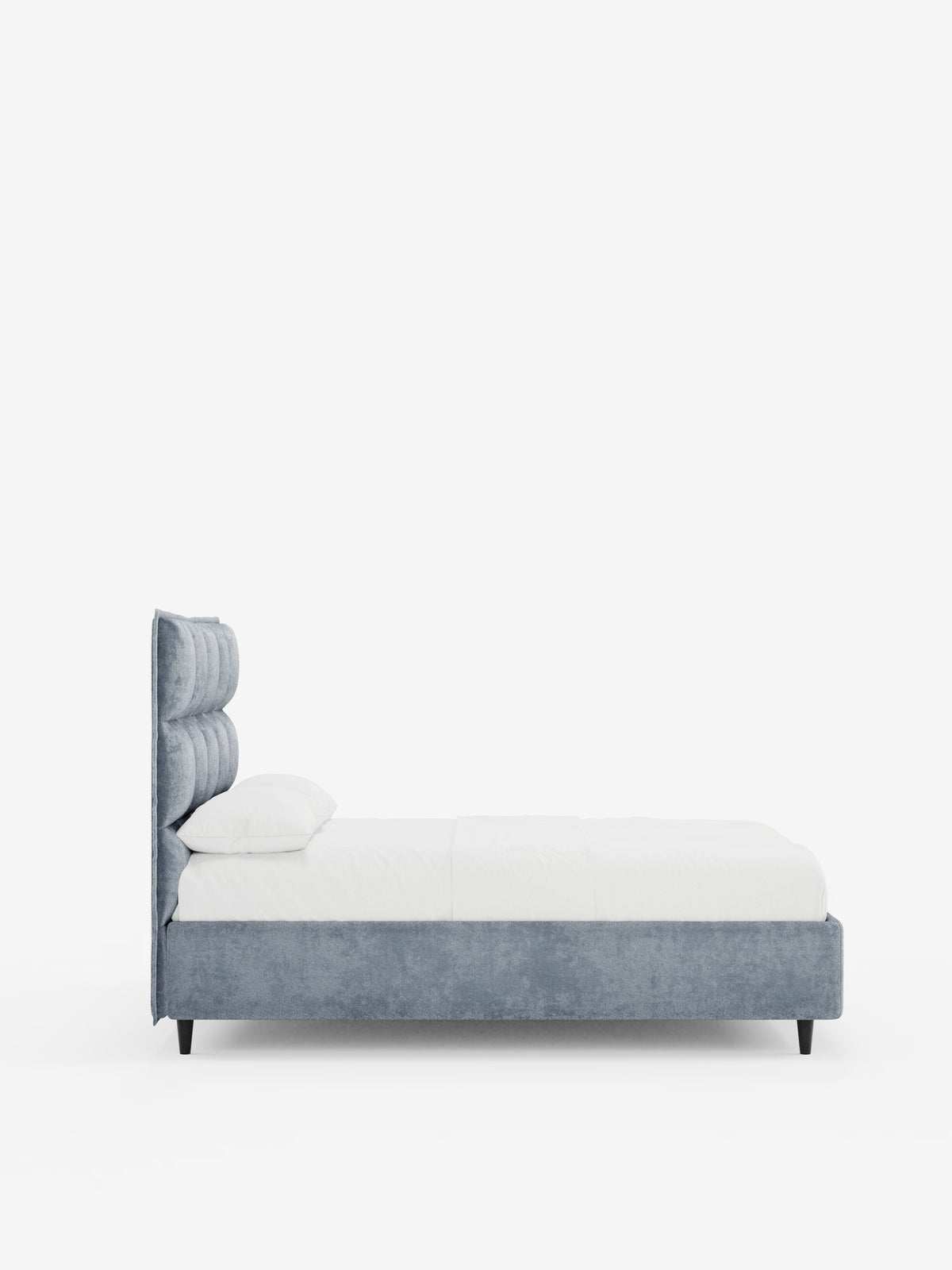 Vista laterale del letto imbottito AURO con vano contenitore di Letti.store, caratterizzato da un’alta testiera capitonné in tessuto chenille azzurro certificato Oeko-Tex®. Il letto è abbinato a biancheria da letto bianca e due cuscini, su uno sfondo bianco a tinta unita che ne esalta il design minimalista e la morbida trama.