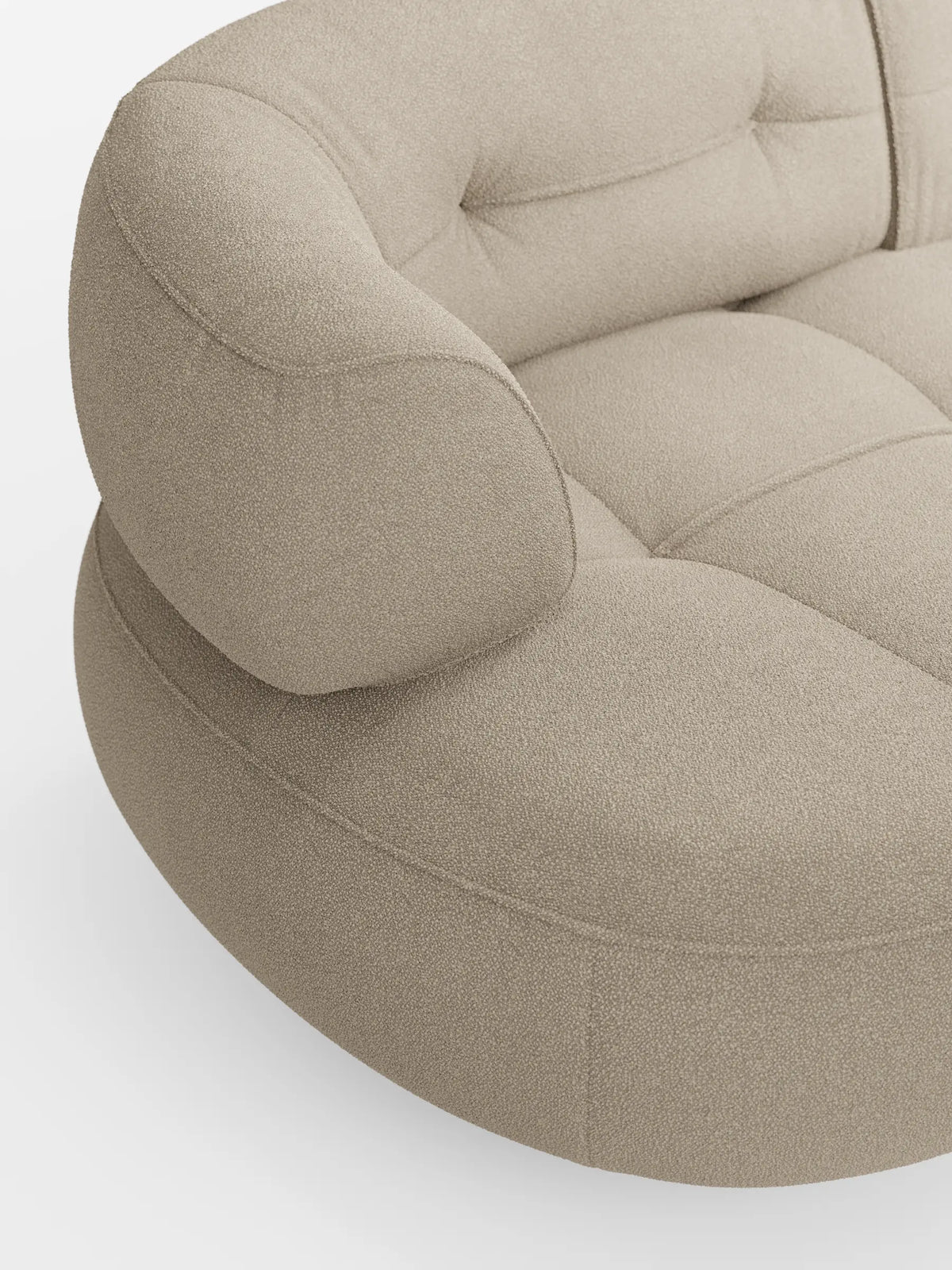 Un divano curvo a fagiolo a 3 posti color beige chiaro, dalla struttura testurizzata, modello “Croissant”, con schienali traslanti in morbido tessuto effetto cotone smacchiabile T33, caratterizzato da una profonda trapuntatura e braccioli arrotondati su uno sfondo bianco e pulito.
