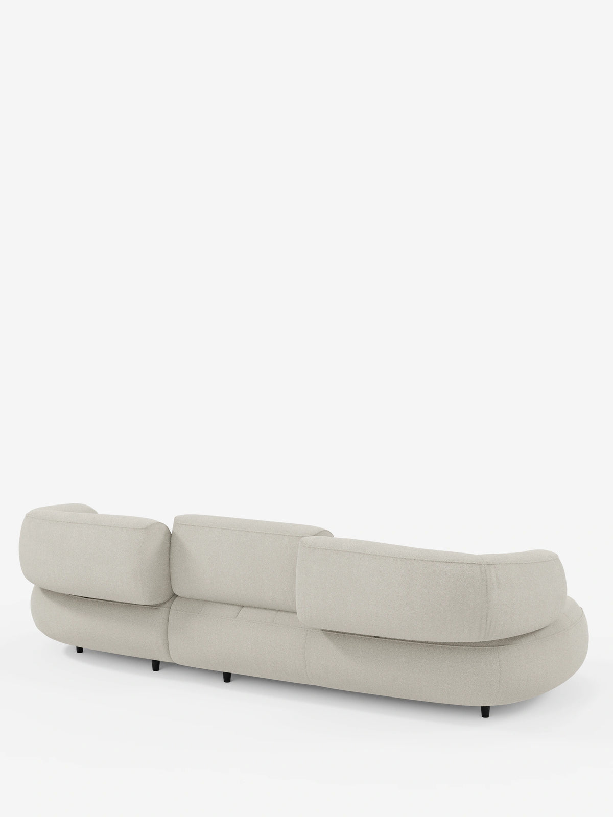 Il divano angolare Croissant, dal design a fagiolo e con schienali traslanti in morbido tessuto effetto cotone smacchiabile T33, è un moderno divano modulare a forma di fagiolo color beige chiaro con tre sezioni di schienale su piedini neri, visto da dietro.
