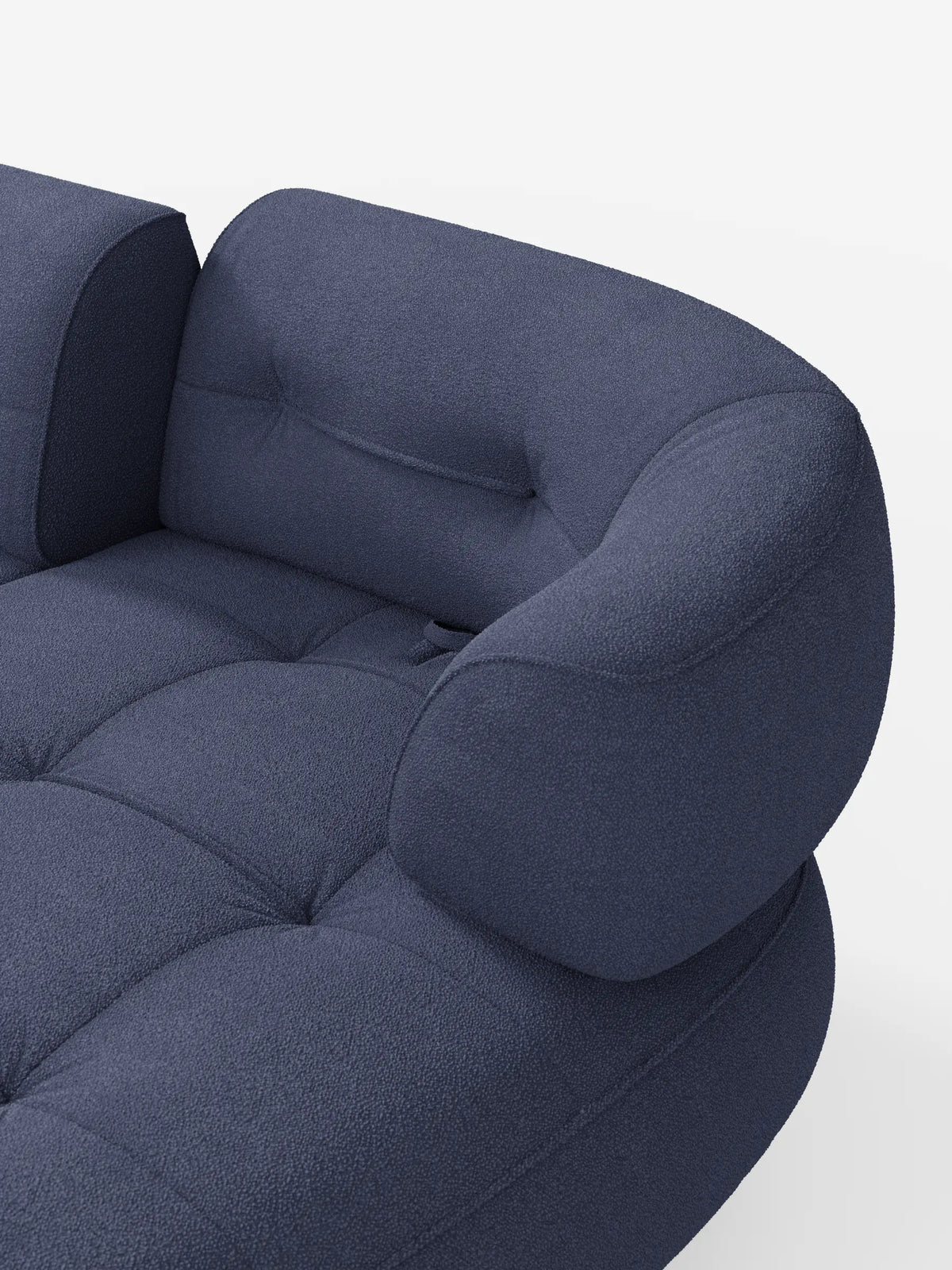 Un divano angolare Croissant dalla forma ricurva a fagiolo, con schienali traslanti in morbido tessuto effetto cotone smacchiabile T33, rivestito in tessuto blu scuro con seduta trapuntata e schienali arrotondati su sfondo bianco.