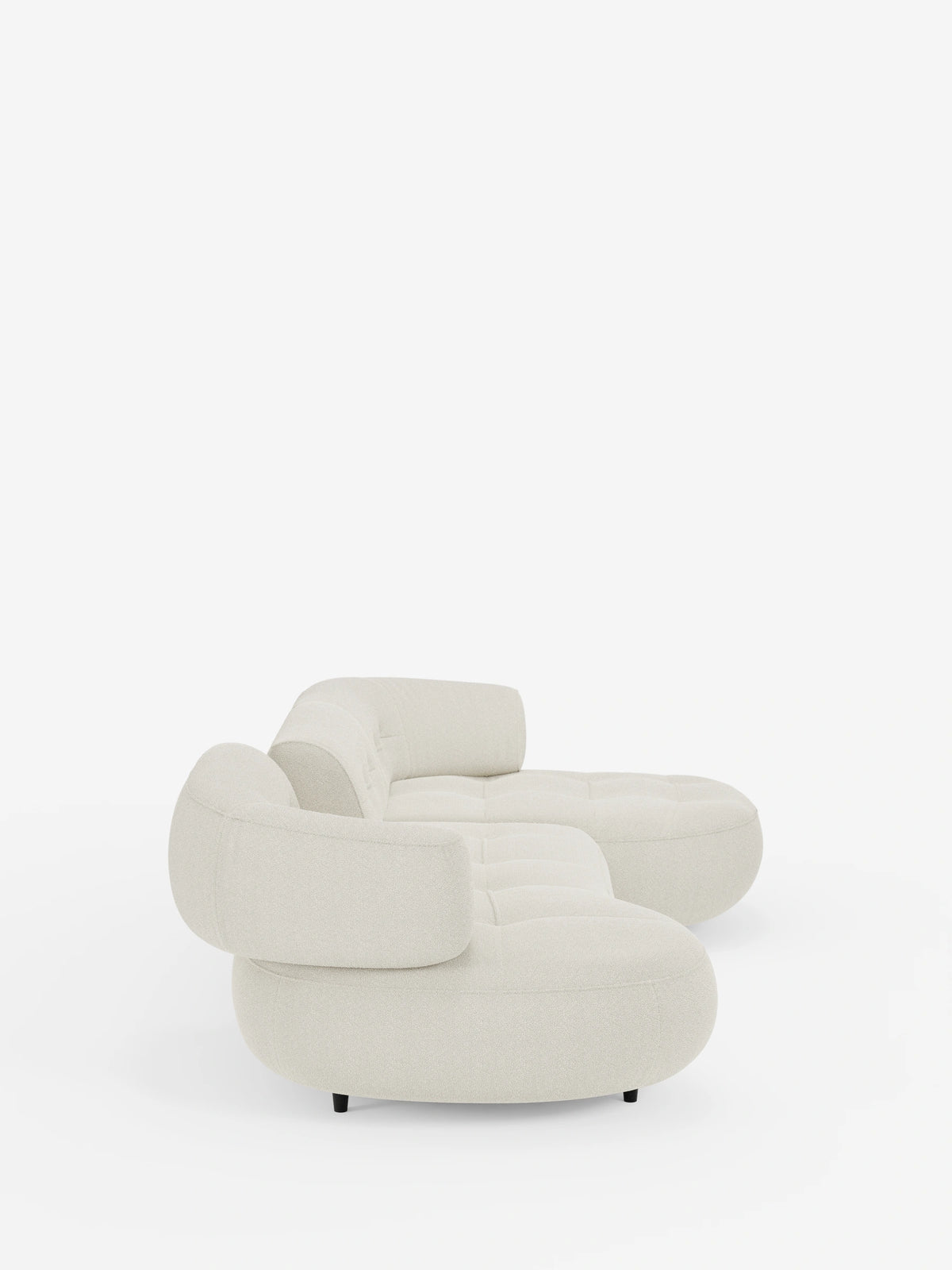 Un divano angolare Croissant dalle linee curve e dal colore crema, dal design a forma di fagiolo e con schienali scorrevoli in morbido tessuto effetto cotone smacchiabile T33, caratterizzato da una silhouette a fagiolo, bordi arrotondati, tessuto testurizzato e cuscini trapuntati, poggiato su piedini bassi e scuri.