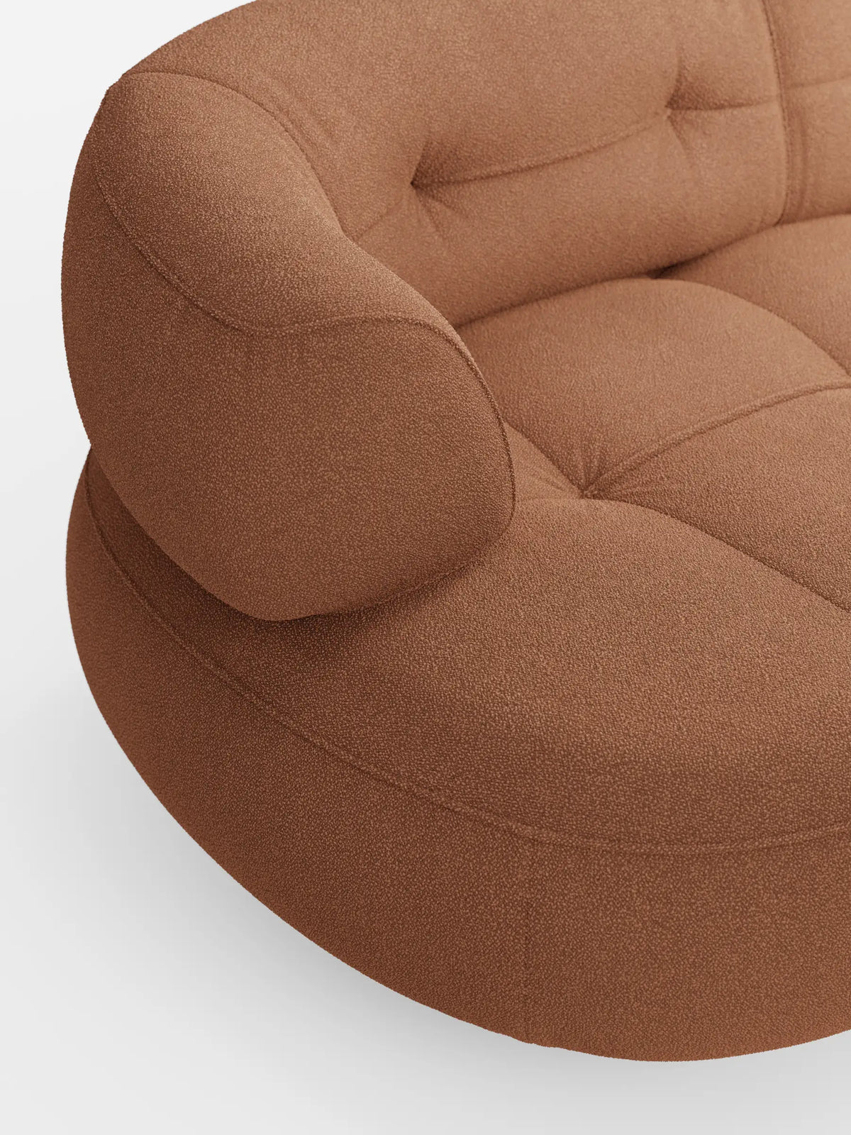 Un divano angolare Croissant dalla forma ricurva a fagiolo, con schienali scorrevoli rivestiti in morbido tessuto effetto cotone smacchiabile T33, in tessuto testurizzato color terracotta con dettagli trapuntati e braccioli arrotondati.