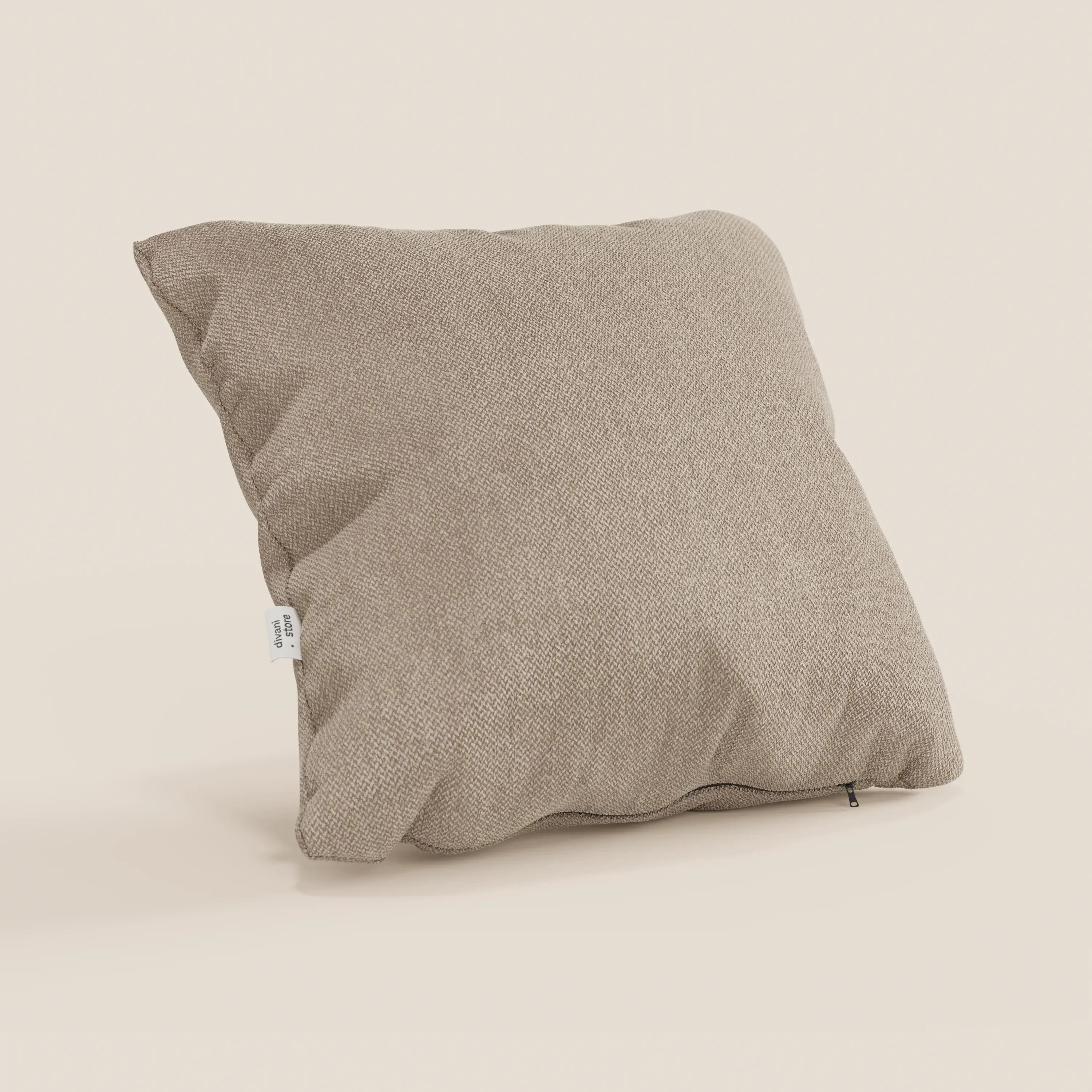 Il cuscino Sogno di Divani.Store in smacchiabile T05 beige è caratterizzato da un tessuto morbido e strutturato, da una forma quadrata, da una piccola etichetta laterale bianca e da una cerniera sul fondo.