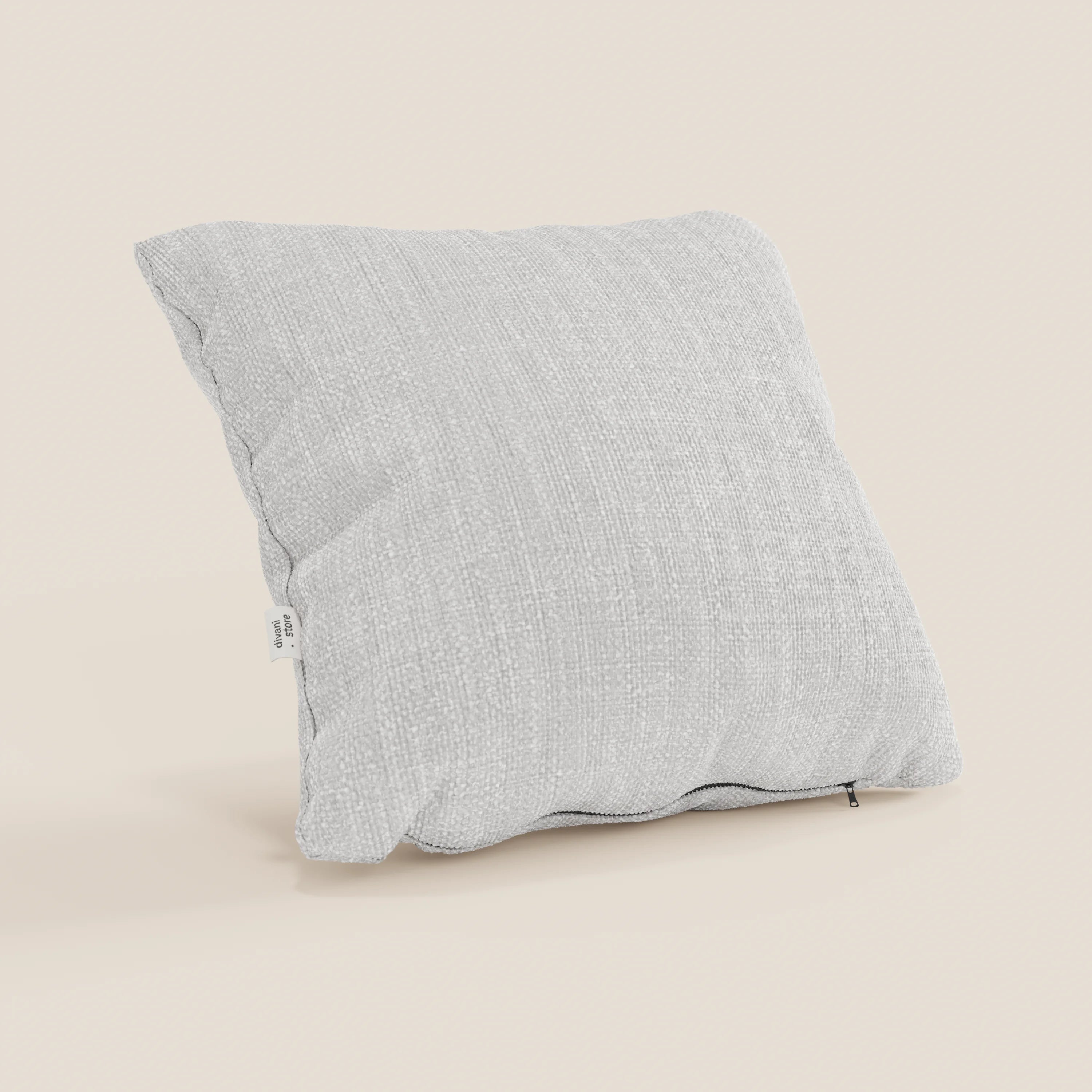 Il cuscino Lyon di Divani.Store, nel formato 45x45 cm T06 grigio chiaro, è caratterizzato da un tessuto morbido intrecciato impermeabile, una targhetta bianca sulla cucitura sinistra e un tiretto in basso a destra su sfondo beige.