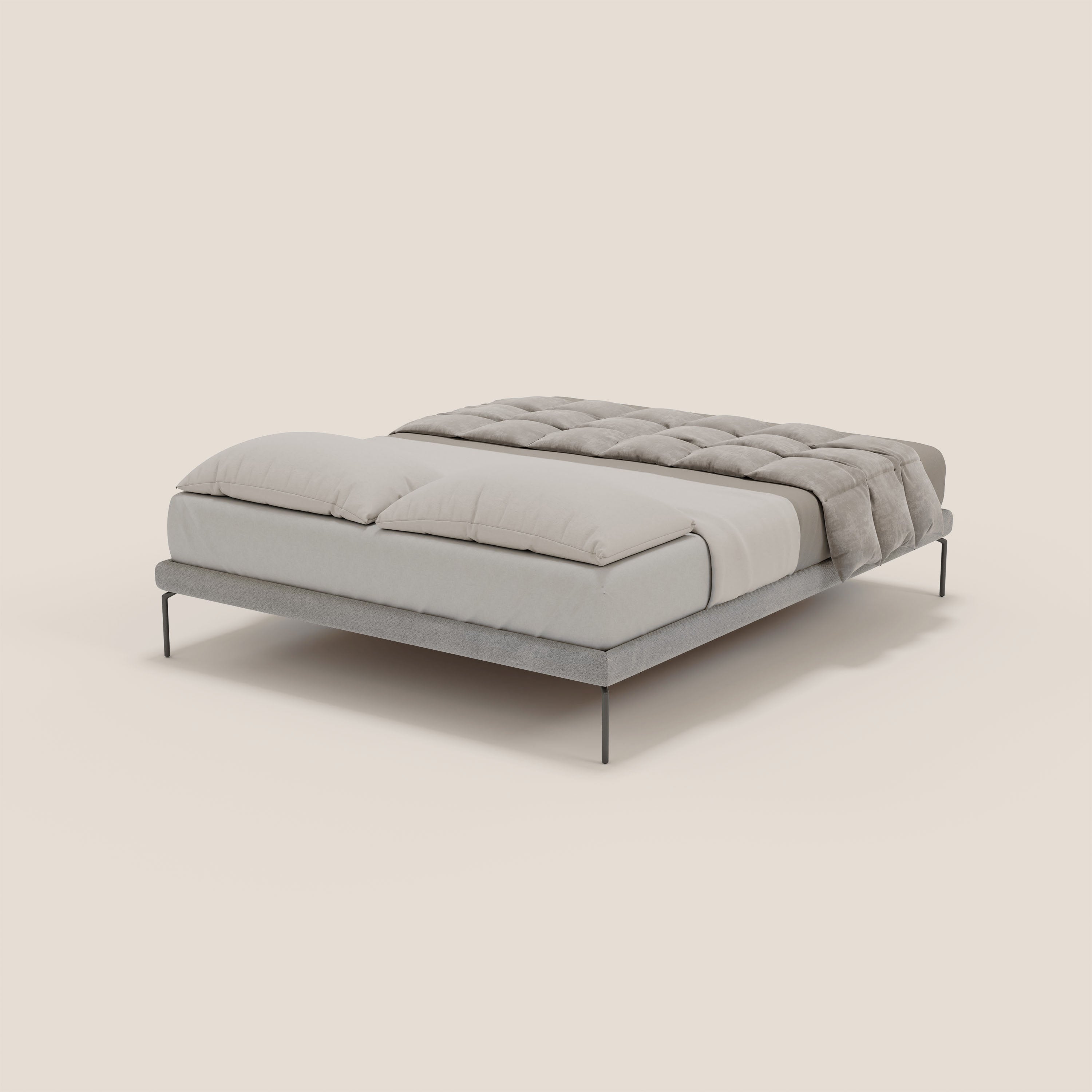 Un Ring sommier sfoderabile minimalista e moderno di Letti.store con gambe nere alte 24 cm in tessuto impermeabile T14 grigio chiaro, sormontato da due grandi cuscini e da un piumino grigio chiaro. Lo sfondo è semplice, beige chiaro e ordinato.