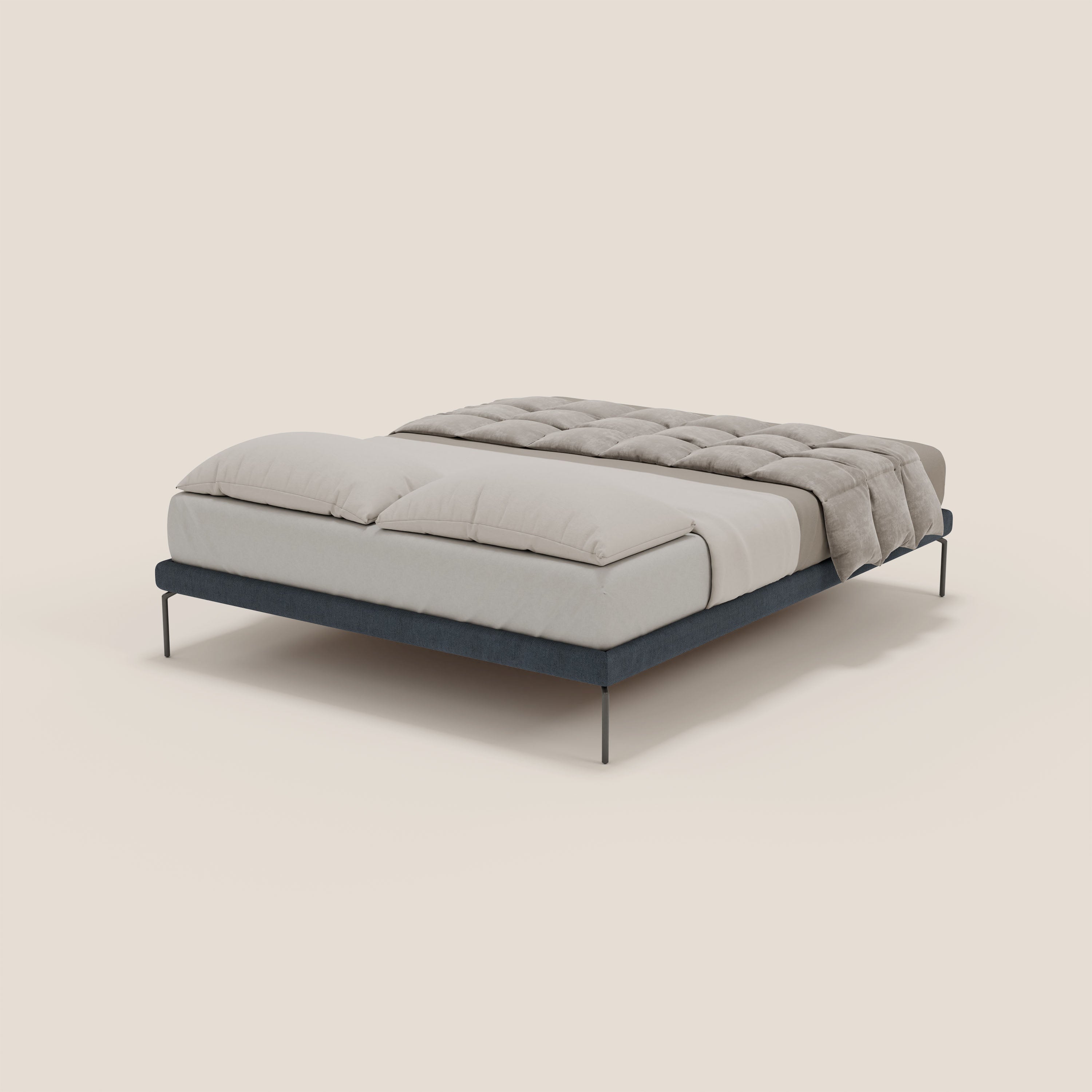Il sommier sfoderabile Ring di Letti.store, con gambe alte 24 cm e tessuto impermeabile blu T14, è un elegante design italiano con una struttura elegante, due grandi cuscini bianchi e un piumone beige chiaro su un materasso bianco.