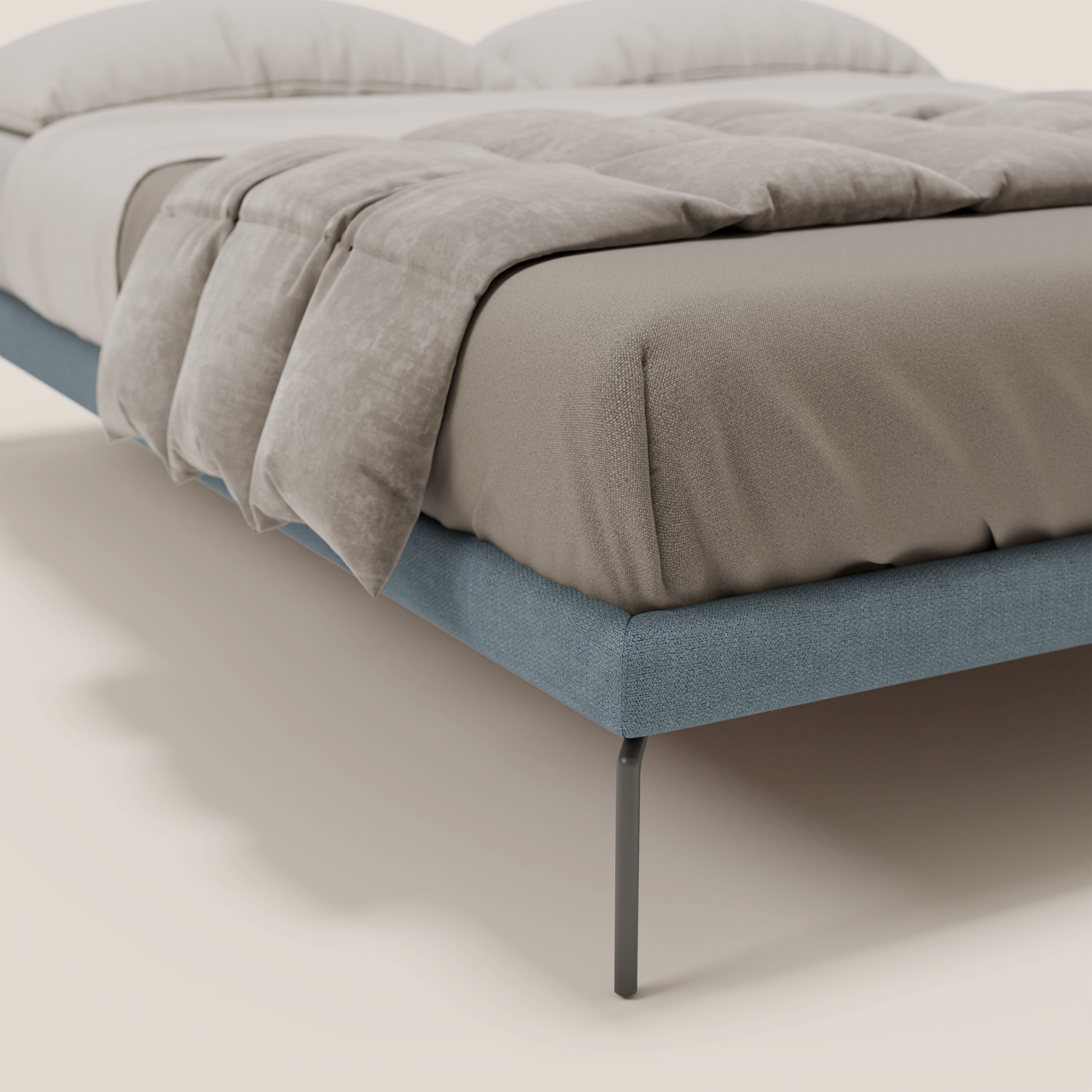 Il sommier sfoderabile Ring di Letti.store è caratterizzato da gambe in metallo nero alte 24 cm e tessuto impermeabile T14 carta da zucchero. Vestito con lenzuolo matrimoniale beige, piumone grigio e cuscini, si staglia su uno sfondo bianco sporco.