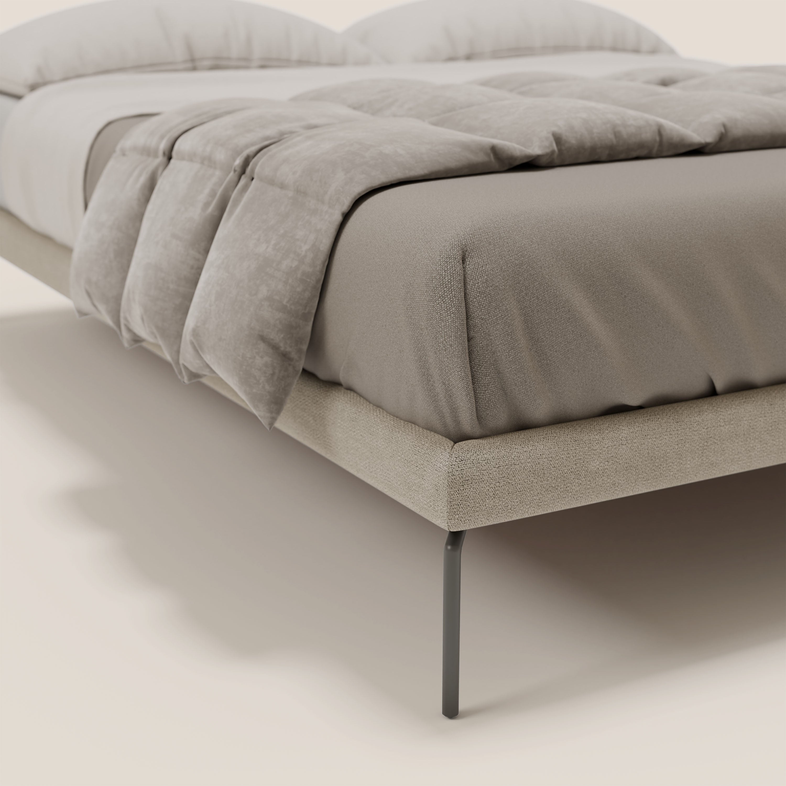 Primo piano del sommier sfoderabile Ring di Letti.store con gambe in metallo nero alte 24 cm in tessuto tortora impermeabile T14, sormontato da un lenzuolo matrimoniale color tortora e da un piumone grigio chiaro, che mette in mostra il design minimalista italiano con luci soffuse.