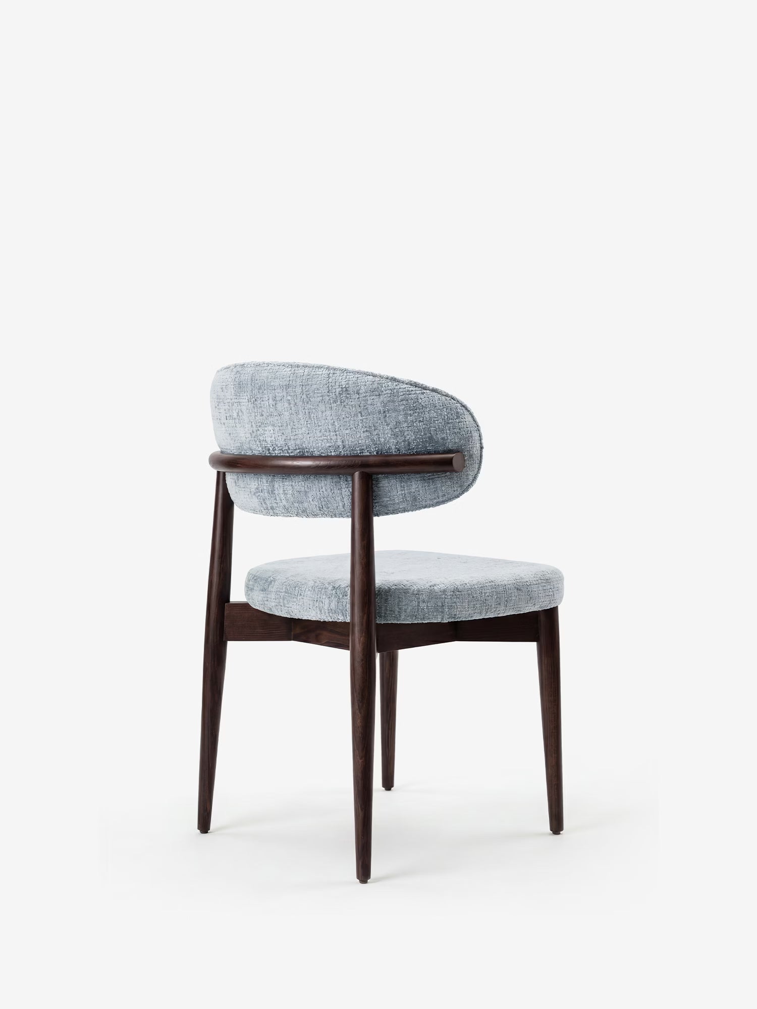 La sedia Dafne di Divani.Store presenta uno schienale e una seduta curvi e imbottiti in ciniglia azzurra certificata OEKO-TEX®, con struttura e gambe in legno massello di wengé. Il suo design minimalista risalta su uno sfondo bianco a tinta unita.