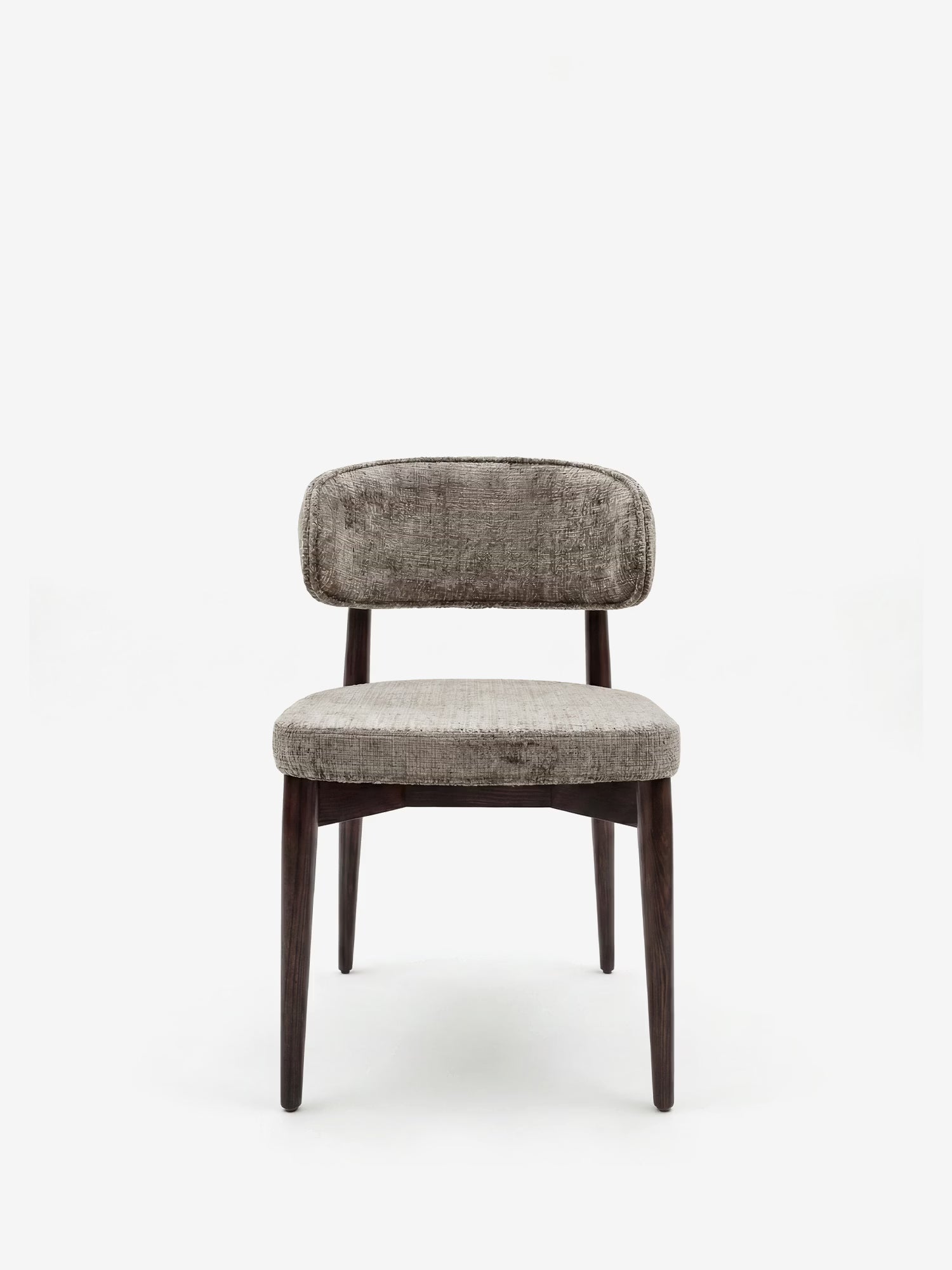 La sedia Dafne di Divani.Store presenta una seduta imbottita in ciniglia grigia certificata OEKO-TEX® e uno schienale arrotondato, un design minimalista senza braccioli e quattro gambe in legno massello di wengé: perfetta per gli spazi contemporanei.