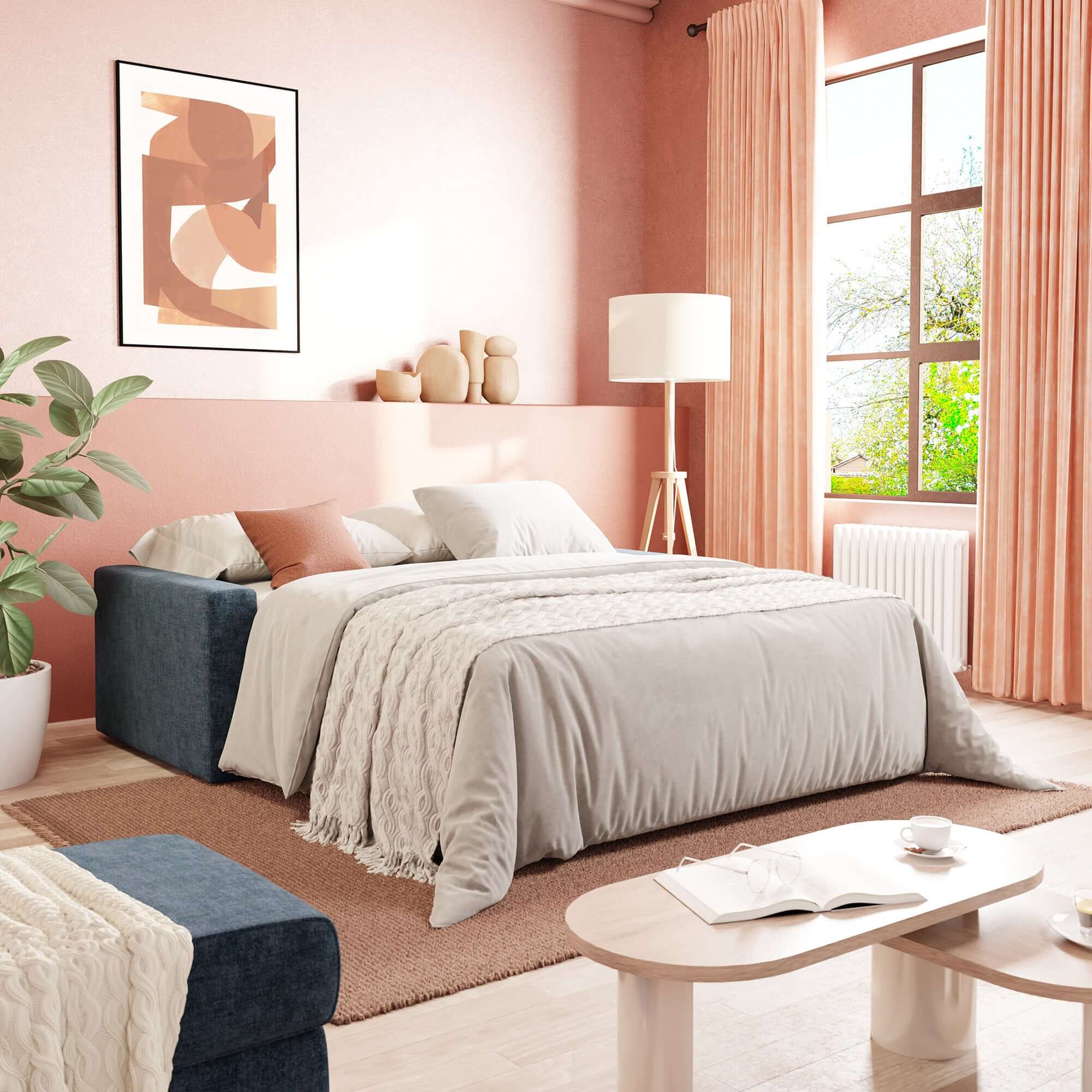 Una camera da letto moderna con pareti color pesca, un'ampia finestra con tende abbinate e il Diomede Divano letto matrimoniale in velluto easy clean sfoderabile T35 blu di Divani.Store, caratterizzato da biancheria leggera, cuscini, una lampada da terra, opere d'arte sopra il letto, piante, vasi e un tavolino in legno.