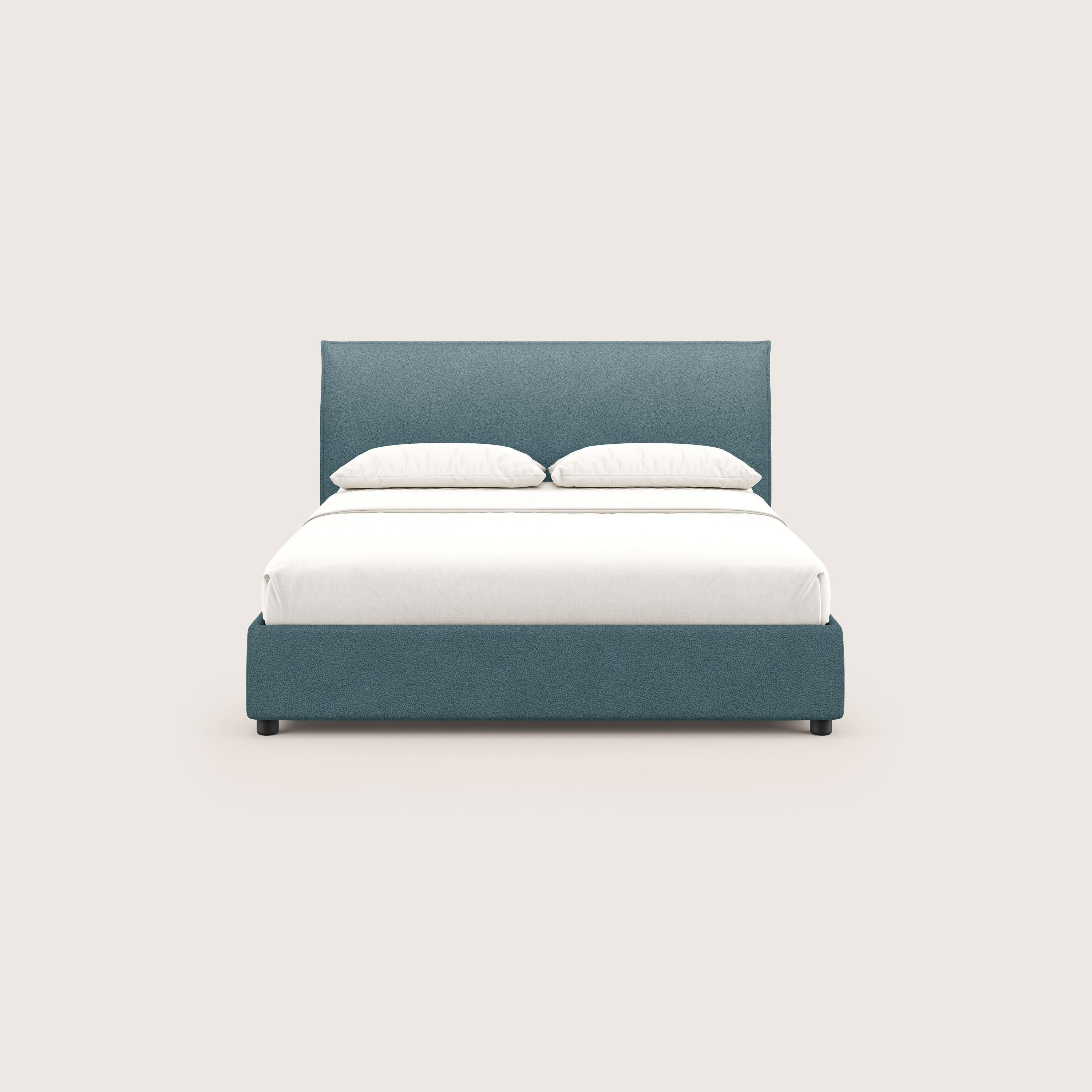 Un letto contenitore Nina di Letti.store, dal design minimale in microfibra effetto pelle antimacchia color verde acqua, è posizionato su uno sfondo beige chiaro con biancheria da letto bianca e due cuscini, a dimostrazione dell'elegante stile italiano.