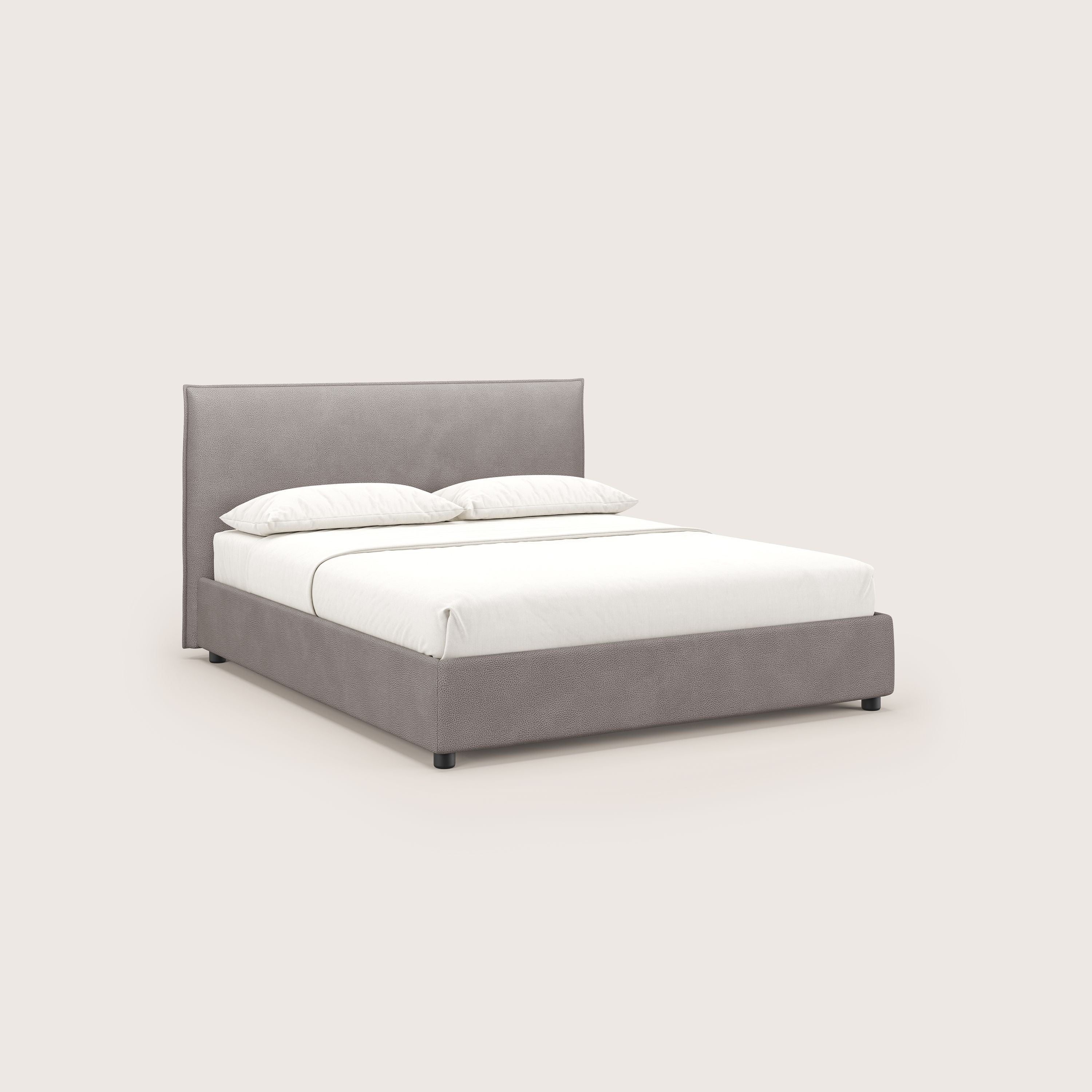 Il letto contenitore Nina di Letti.store è caratterizzato da un design minimal italiano in microfibra effetto pelle grigio tortora, facile da pulire, con linee pulite e senza decorazioni, presentato ordinatamente con biancheria da letto bianca e due cuscini su uno sfondo semplice.