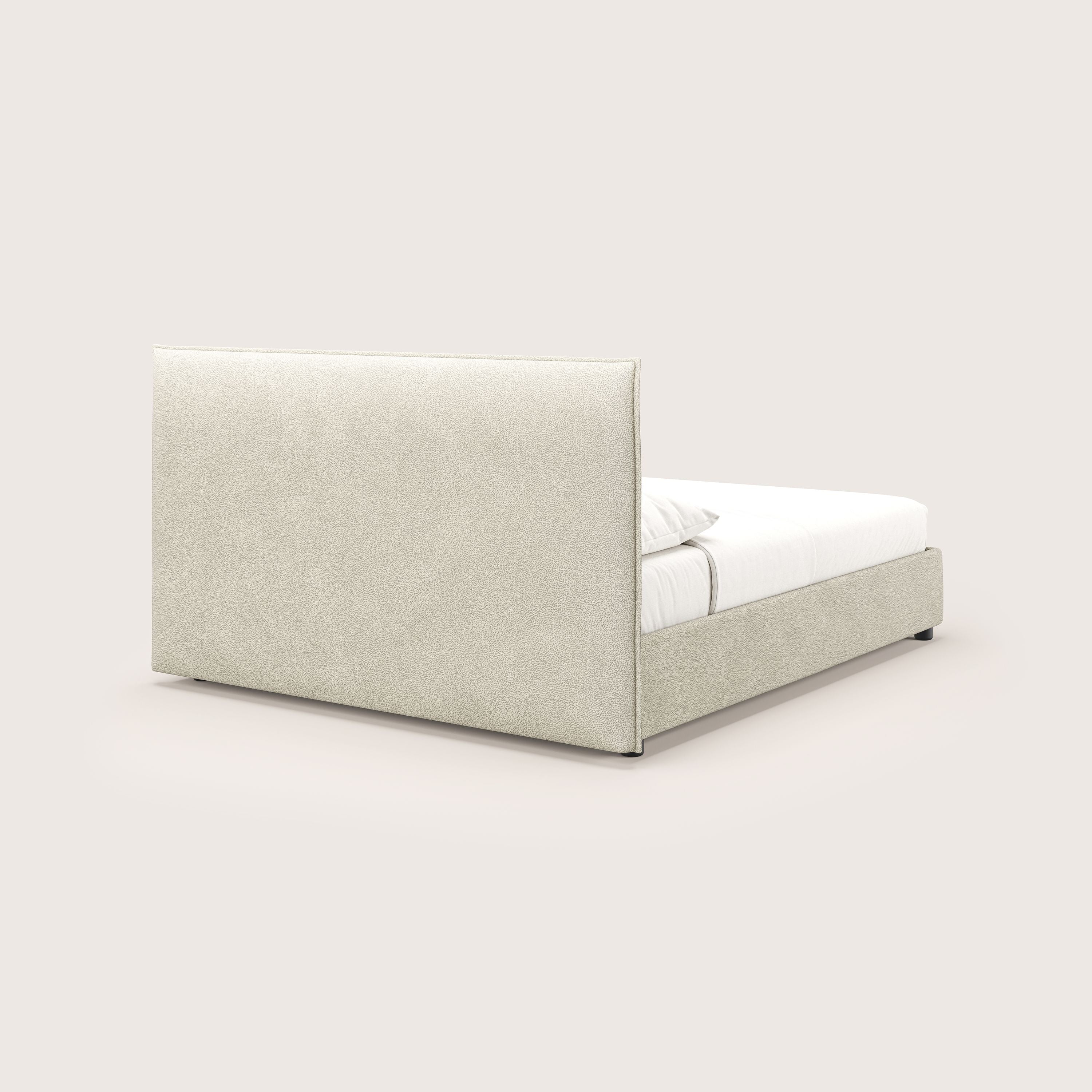 Il letto contenitore Nina di Letti.store è caratterizzato da un design minimale con rivestimento in microfibra effetto pelle panna antimacchia, testata alta e rettangolare e struttura bassa, con materasso e cuscini bianchi su sfondo bianco sporco.