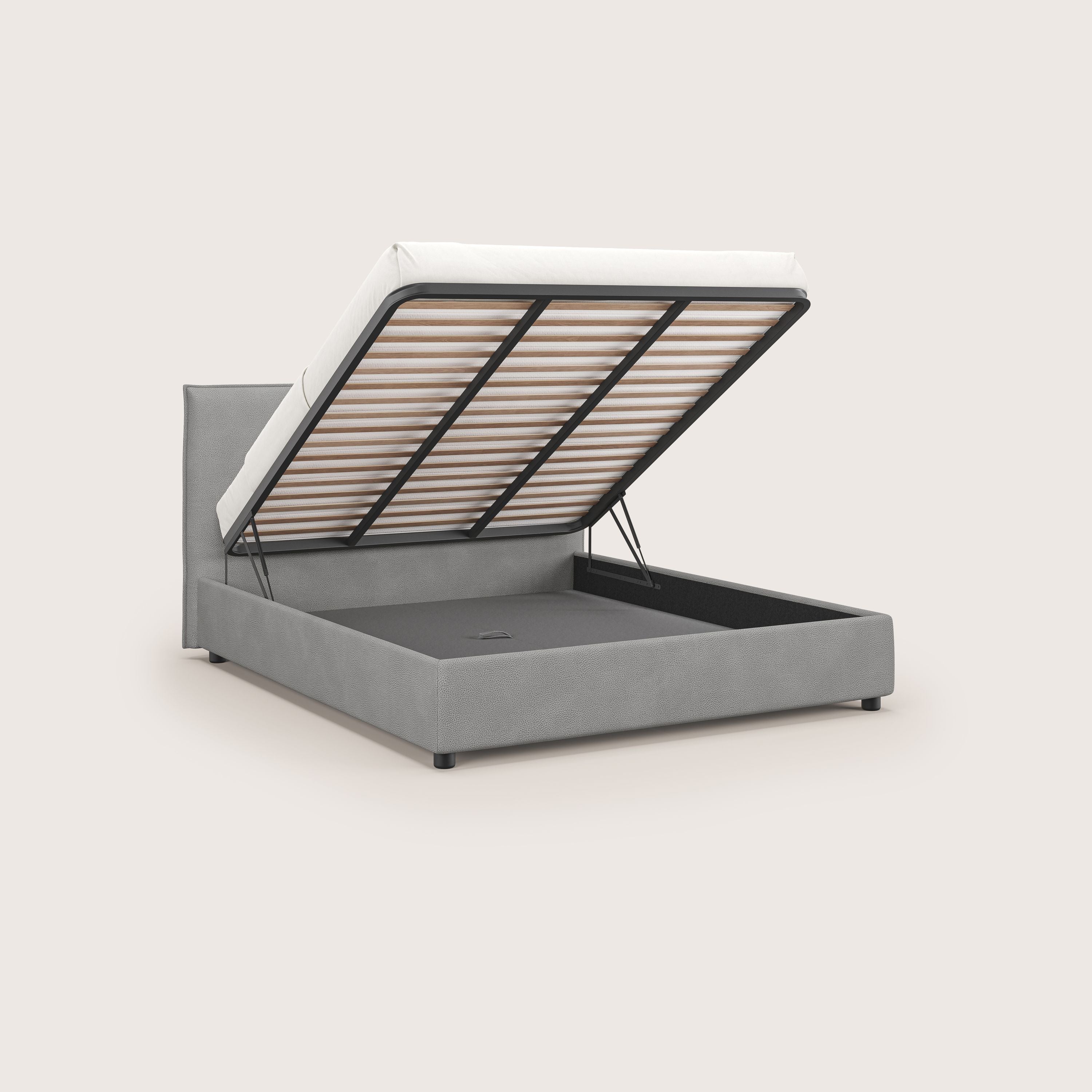 Nina letto contenitore di Letti.store è un letto minimale in microfibra grigia antimacchia effetto pelle, con piattaforma del materasso sollevabile per uno spazioso contenitore sotto il letto. Sostenuto da doghe in metallo nero e sollevatori idraulici, risplende su uno sfondo beige chiaro.