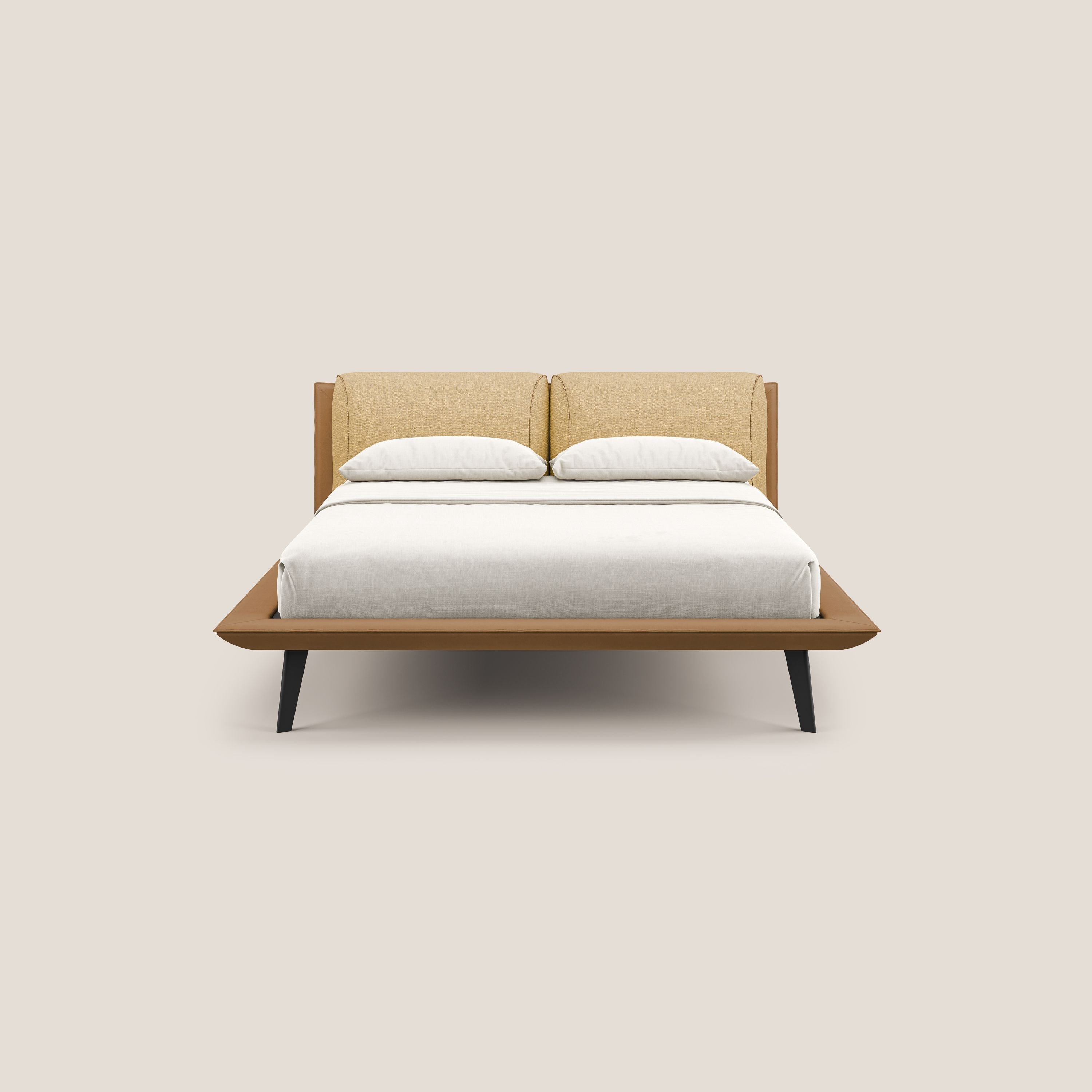 Il letto di design Petra di Letti.store è caratterizzato da un tessuto impermeabile bicolore T11 e T06, cuscini in piuma, struttura in legno e gambe in mogano. Include biancheria da letto bianca, due cuscini ed è presentato su uno sfondo beige semplice.