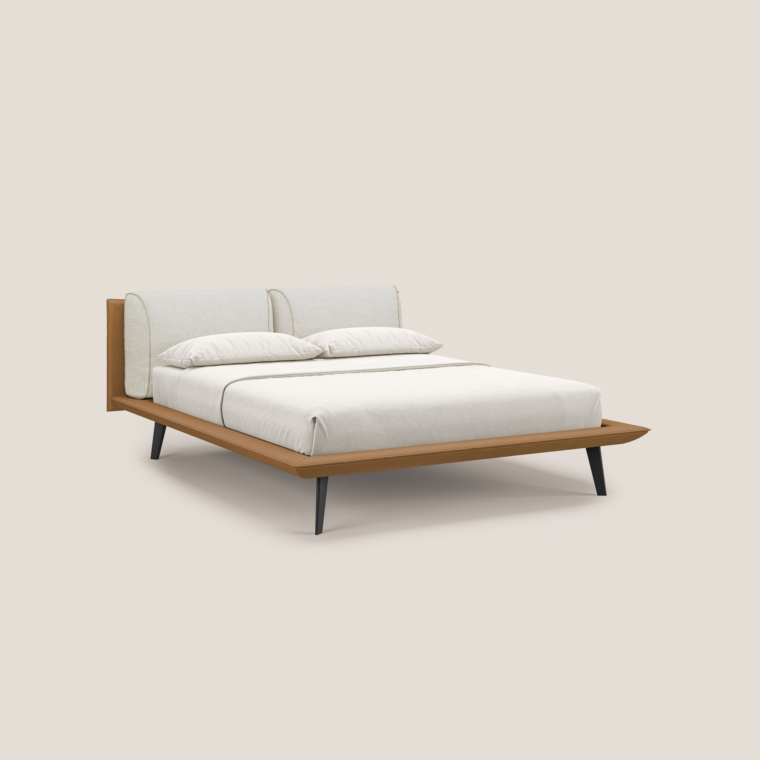 Il letto di design Petra di Letti.store è caratterizzato da un tessuto bicolore impermeabile T11 e T06 (cuoio/panna), cuscini in piuma e piedi in mogano. Il letto è presentato con un'ordinata biancheria da letto bianca e due cuscini su uno sfondo beige chiaro.