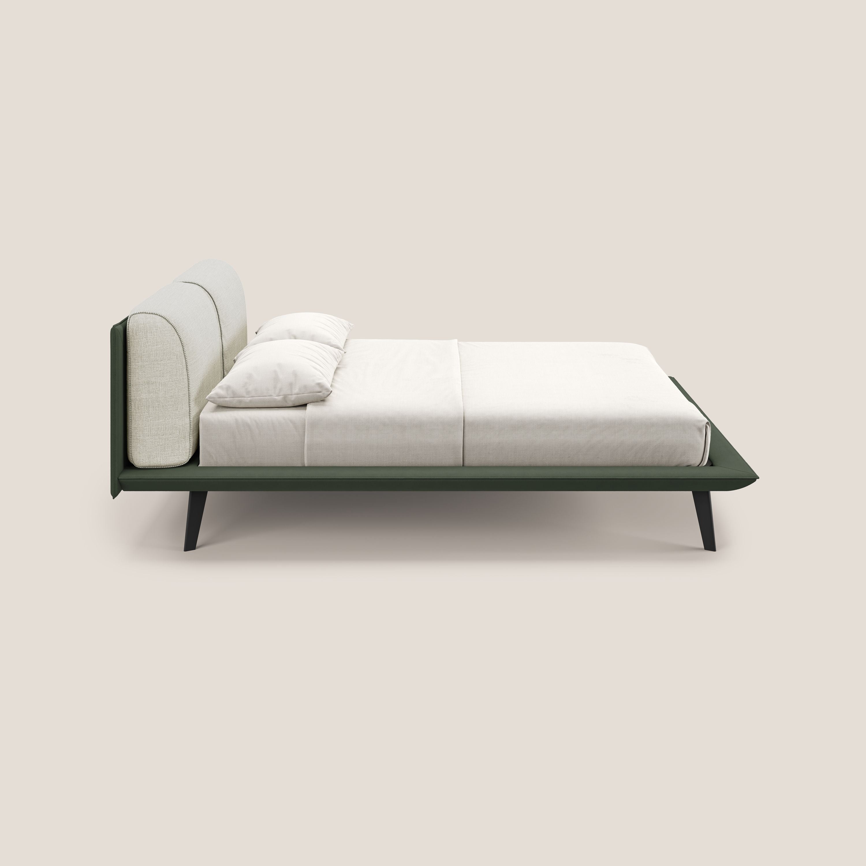 Il letto di design Petra di Letti.store è caratterizzato da un tessuto impermeabile bicolore verde-panna (T11/T06), cuscini in piuma e piedi in mogano. Mostrato di lato con biancheria da letto bianca su sfondo beige chiaro.