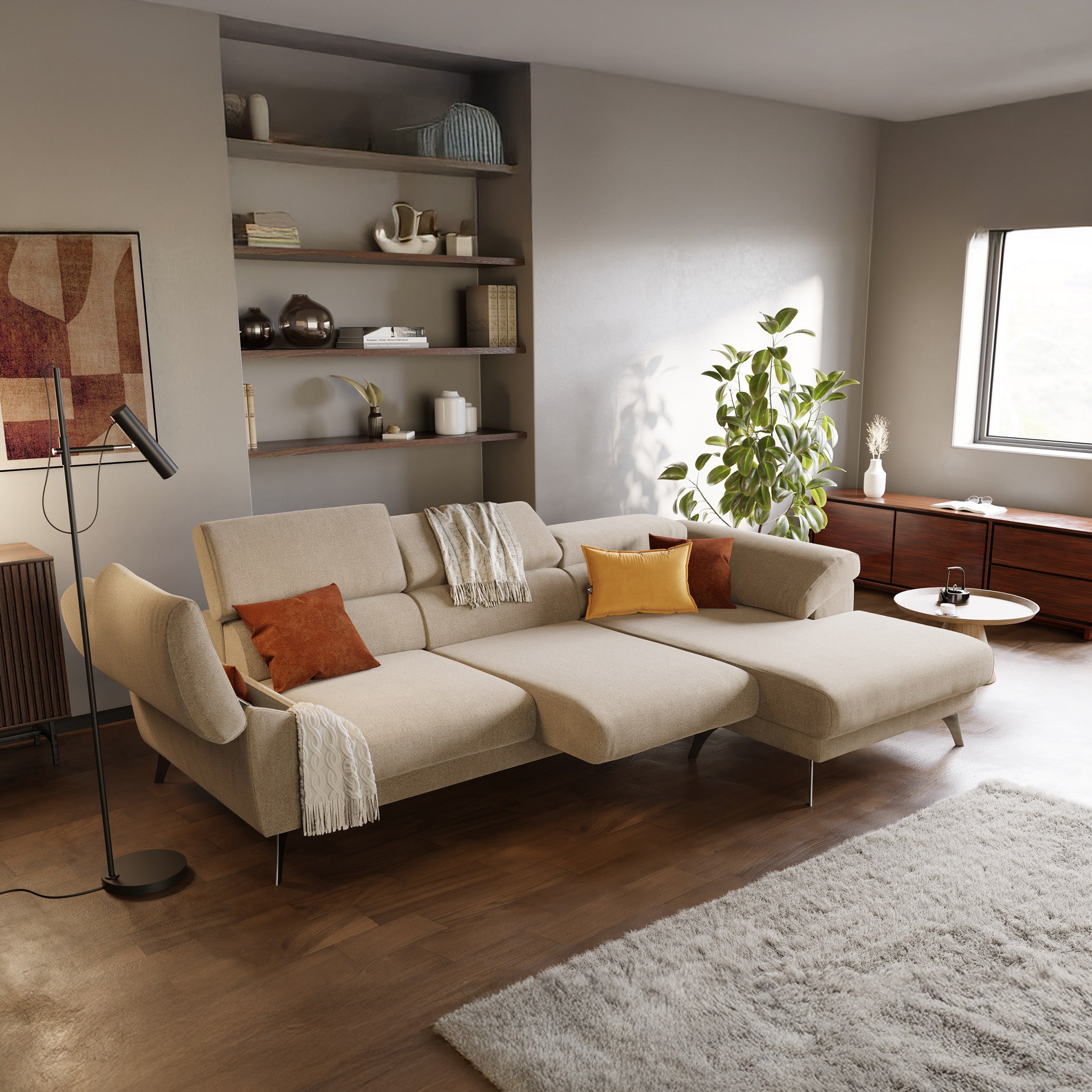 Soggiorno moderno con il divano Donatello Divano angolare T23 beige di Divani.Store, cuscini arancione/beige, copriletto bianco, pianta alta vicino alla finestra, credenza in legno, mensole a muro con decori, lampada da terra e tappeto grigio chiaro su pavimento in legno.