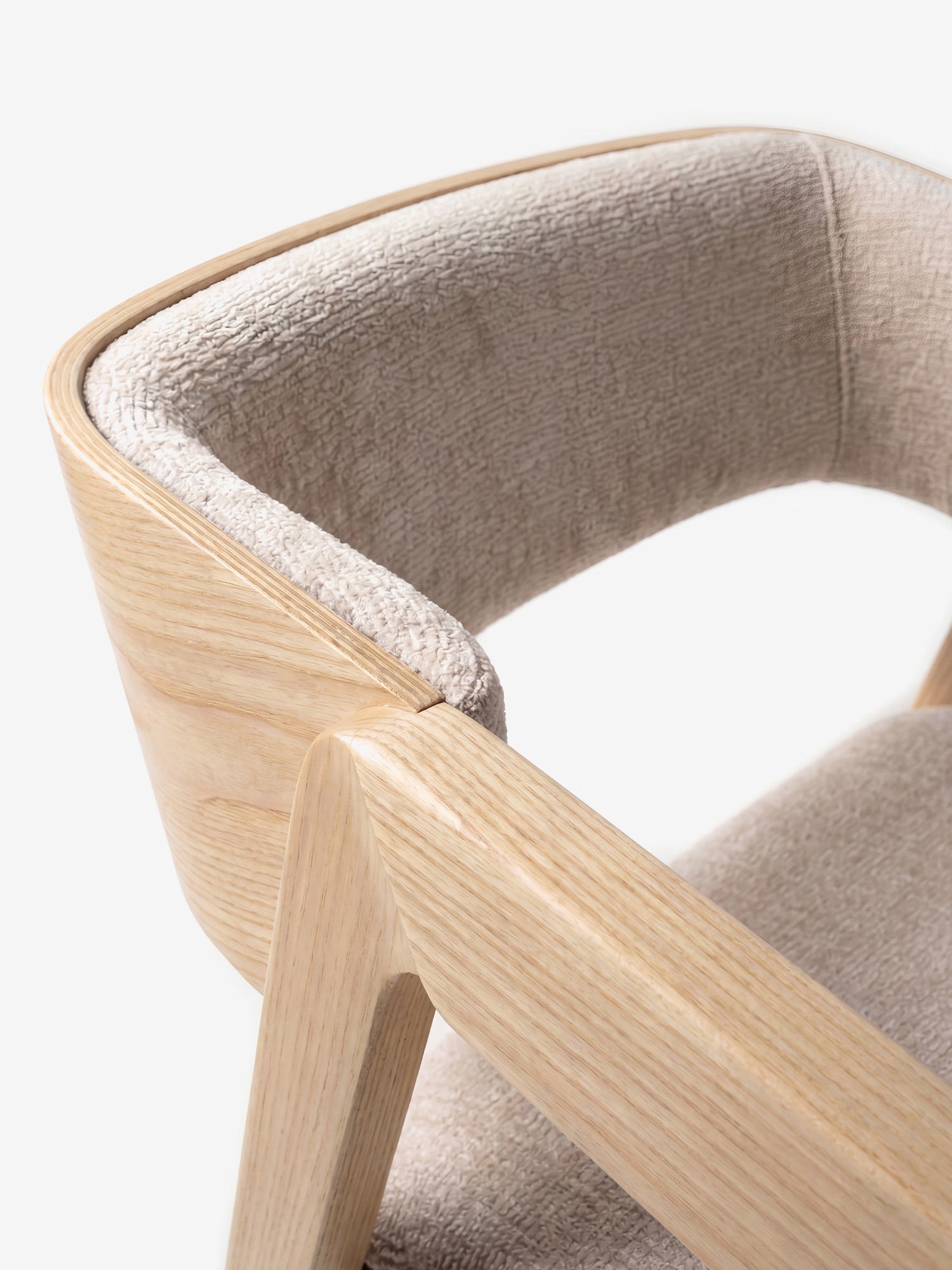 Primo piano della sedia Etra in legno massello naturale di Divani.Store, con braccioli e rivestimento in tessuto beige certificato OEKO-TEX®. Lo schienale e la seduta curvi uniscono linee pulite a un’estetica moderna e naturale.