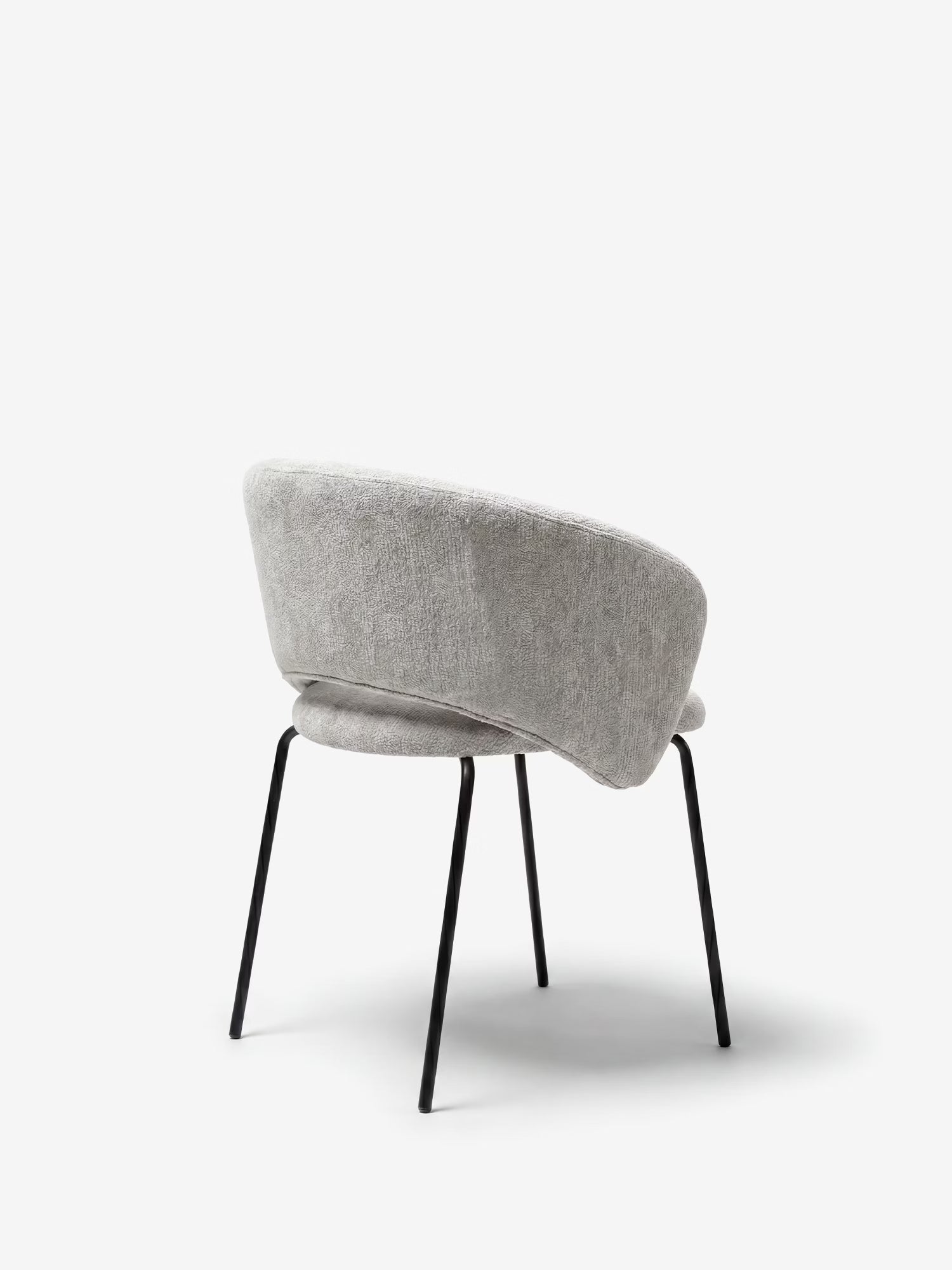 La sedia Fosca di Divani.Store, imbottita e con braccioli, è realizzata in morbido tessuto certificato OEKO-TEX® di colore grigio chiaro e presenta gambe inclinate in metallo nero. Immagine vista da dietro su sfondo bianco.