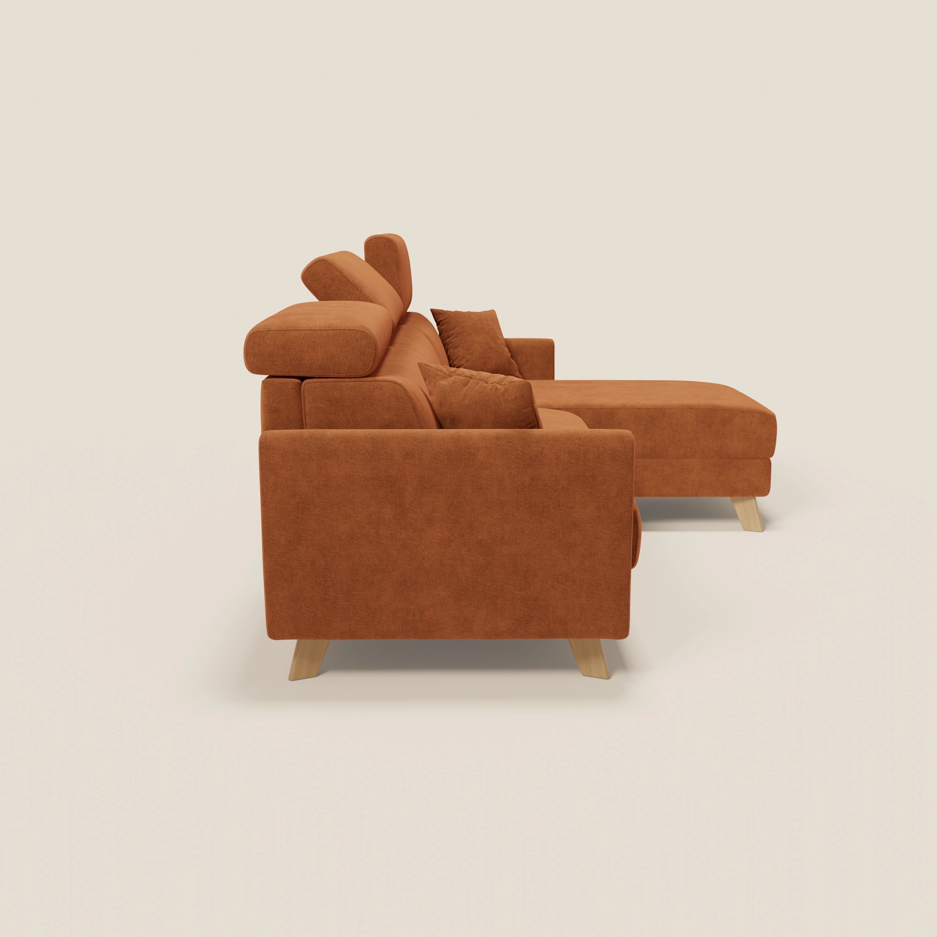 Il divano letto angolare sfoderabile Francy di Divani.Store, in tessuto smacchiabile T17 arancio con poltrona contenitore e poggiatesta reclinabili, è caratterizzato da uno stile nordico su sfondo beige chiaro, visto di lato.