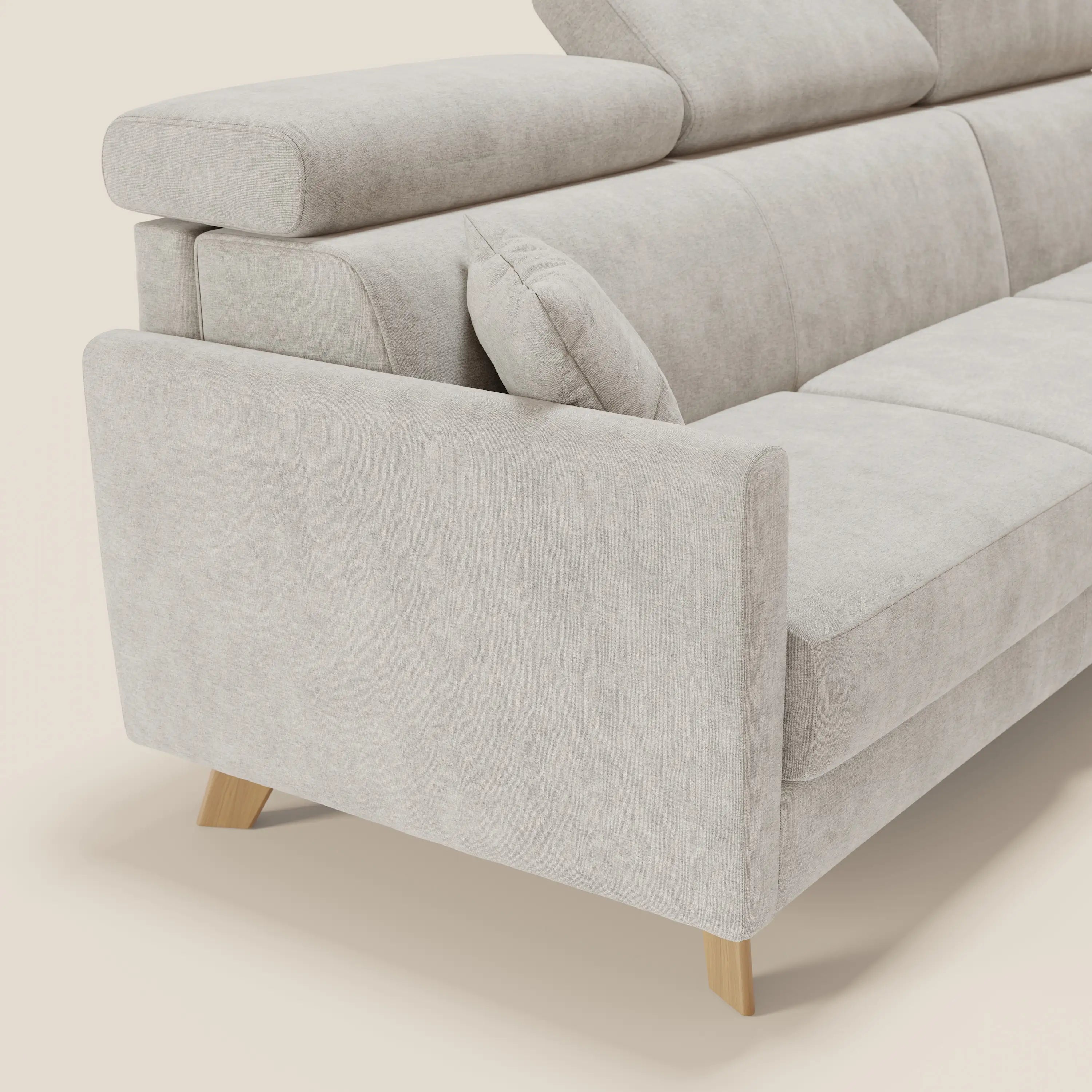 Un primo piano del divano letto angolare Francy sfoderabile di Divani.Store in tessuto smacchiabile T17 bianco, con penisola contenitore, poggiatesta reclinabili e uno stile nordico pulito su uno sfondo neutro.