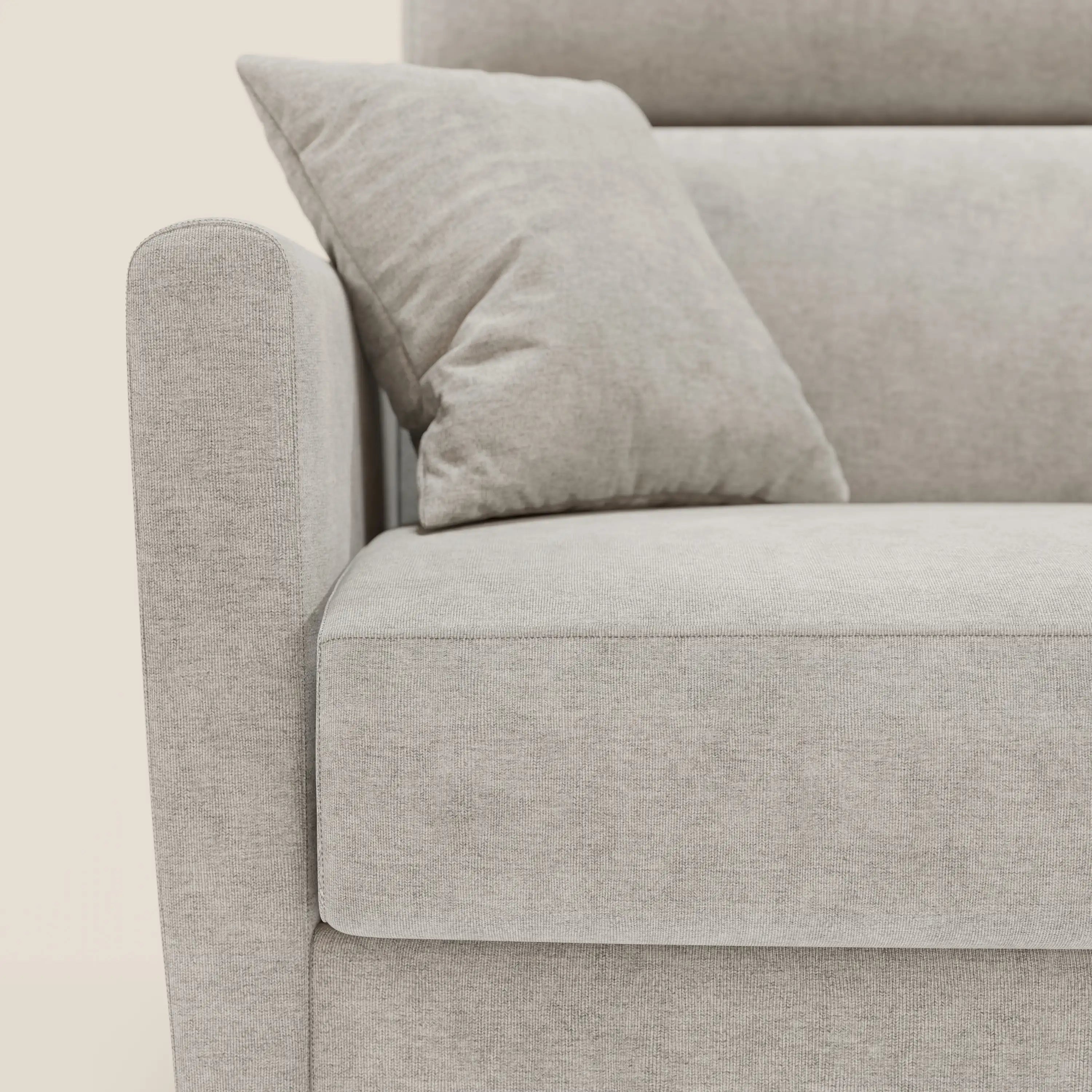 Primo piano del divano letto angolare sfoderabile Francy di Divani.Store in tessuto smacchiabile T17 bianco, con cuscino, penisola contenitore e poggiatesta reclinabili coordinati, su sfondo crema per un look minimalista nordico.