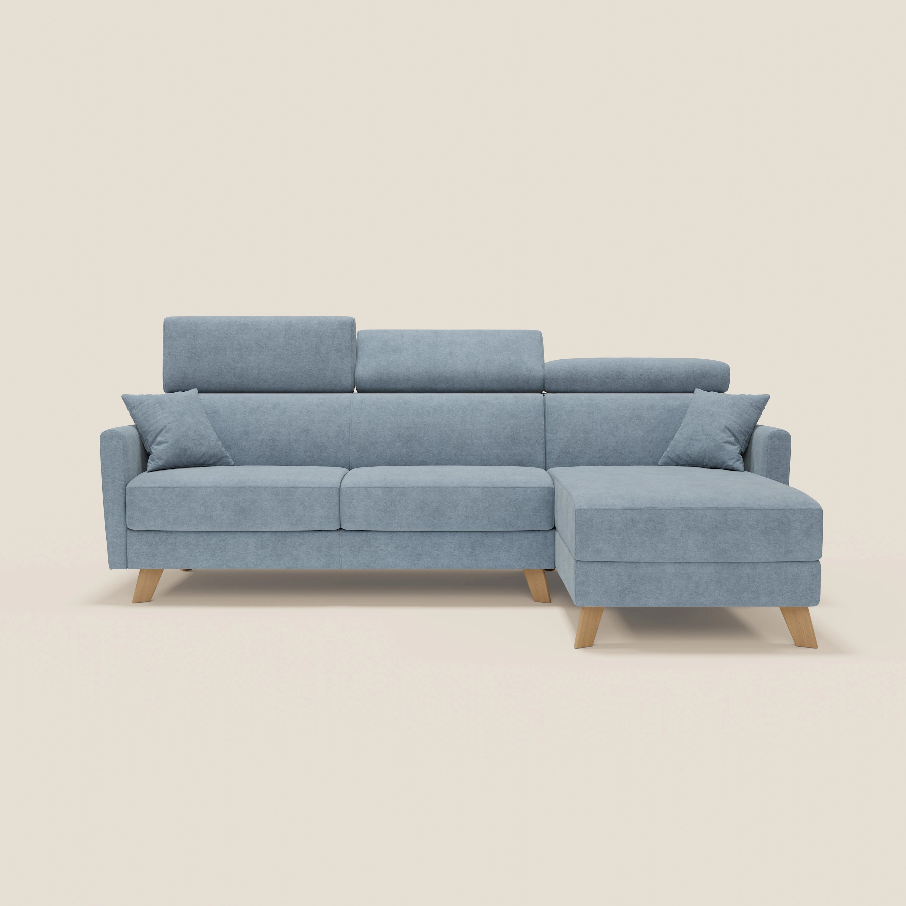 Il divano letto angolare sfoderabile Francy di Divani.Store è dotato di chaise longue con contenitore, poggiatesta reclinabili, tessuto lavabile T17 carta da zucchero, due cuscini e quattro gambe in legno chiaro su sfondo bianco sporco.