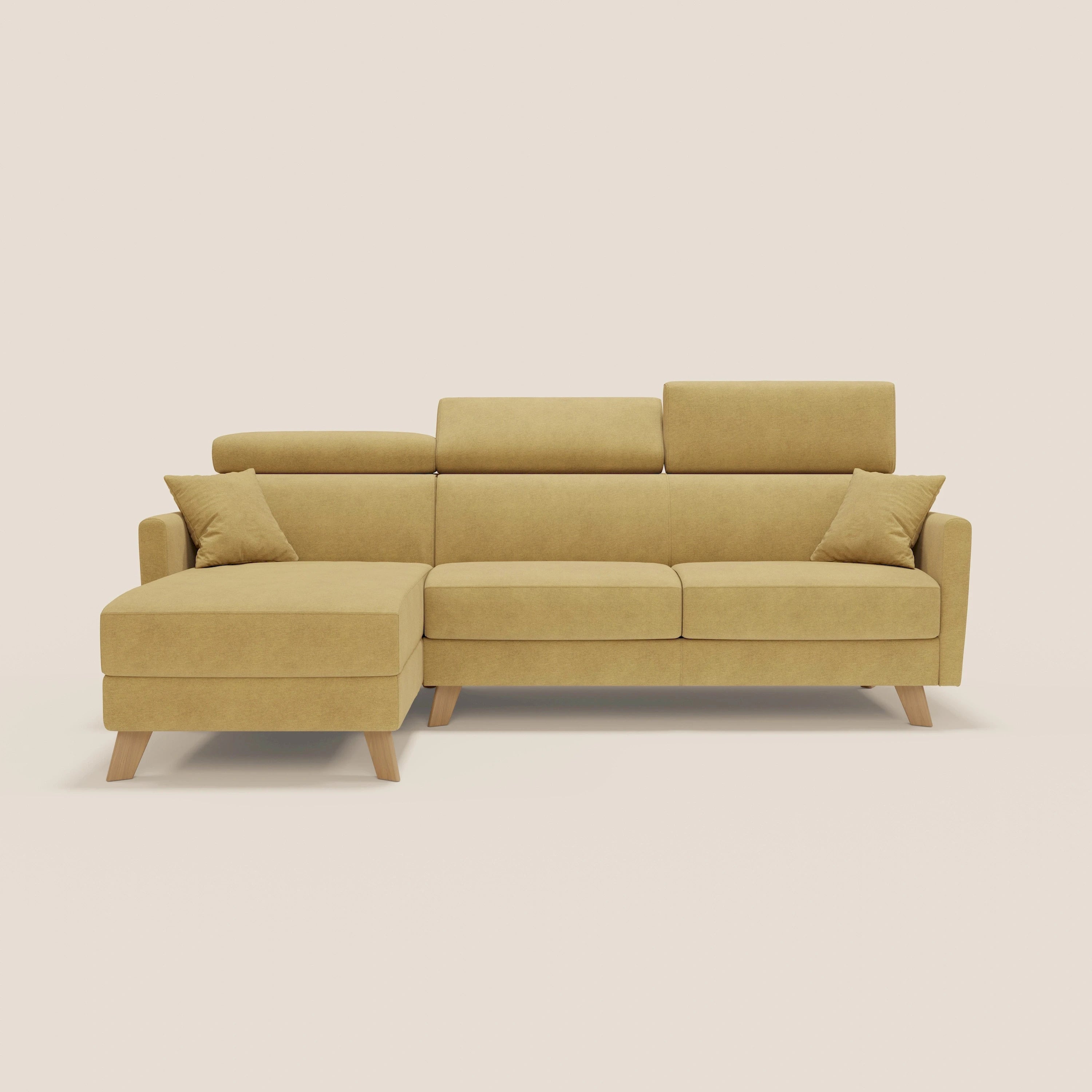 Il divano letto angolare sfoderabile Francy di Divani.Store in T17 giallo è caratterizzato da una chaise longue sinistra con contenitore, tre sedute, poggiatesta reclinabili, gambe in legno e due cuscini coordinati, il tutto su uno sfondo beige chiaro.