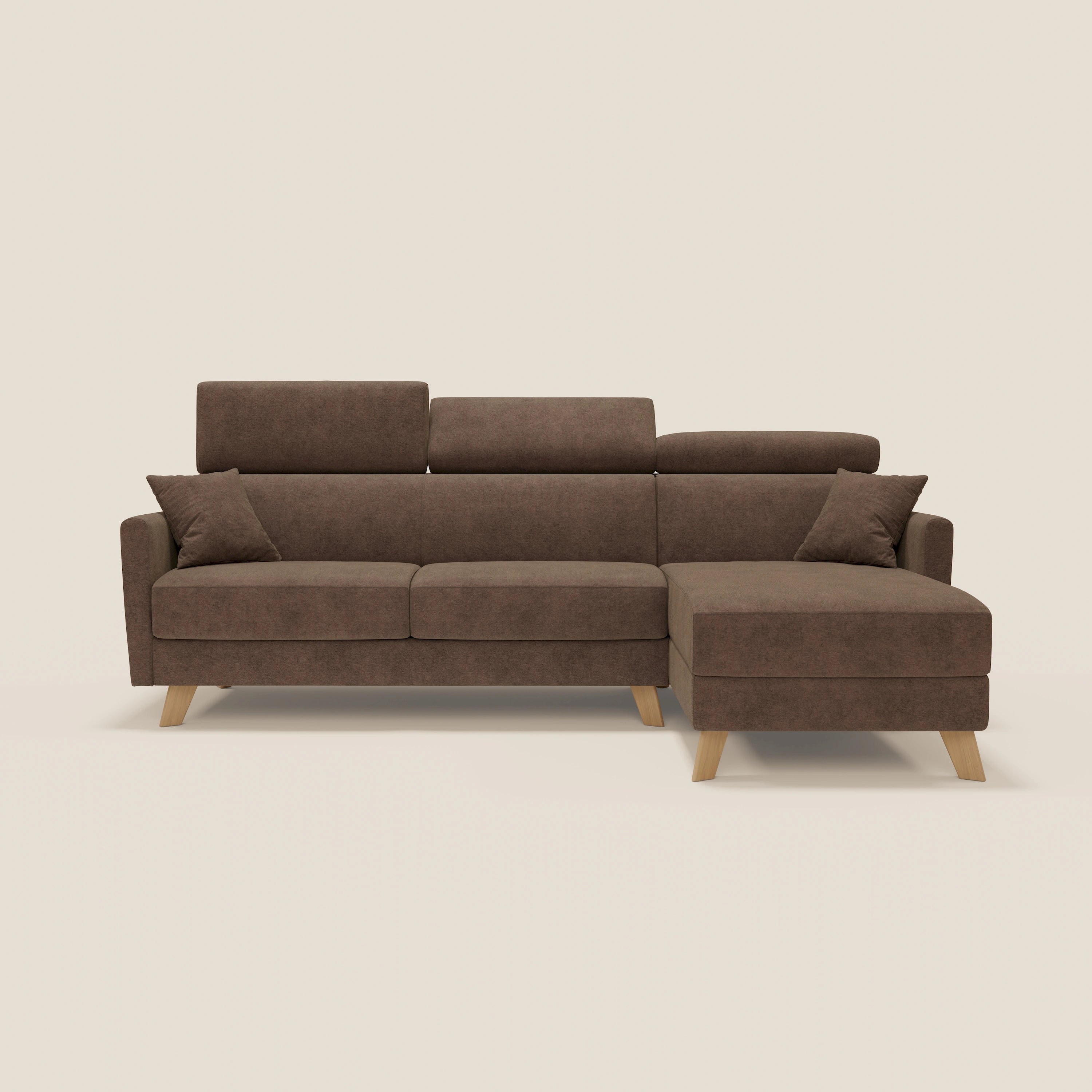 Il divano letto angolare sfoderabile Francy di Divani.Store è caratterizzato da una chaise longue destra con contenitore, poggiatesta reclinabili, tessuto antimacchia sfoderabile in T17 marrone, due cuscini coordinati e gambe in legno, su uno sfondo beige chiaro.