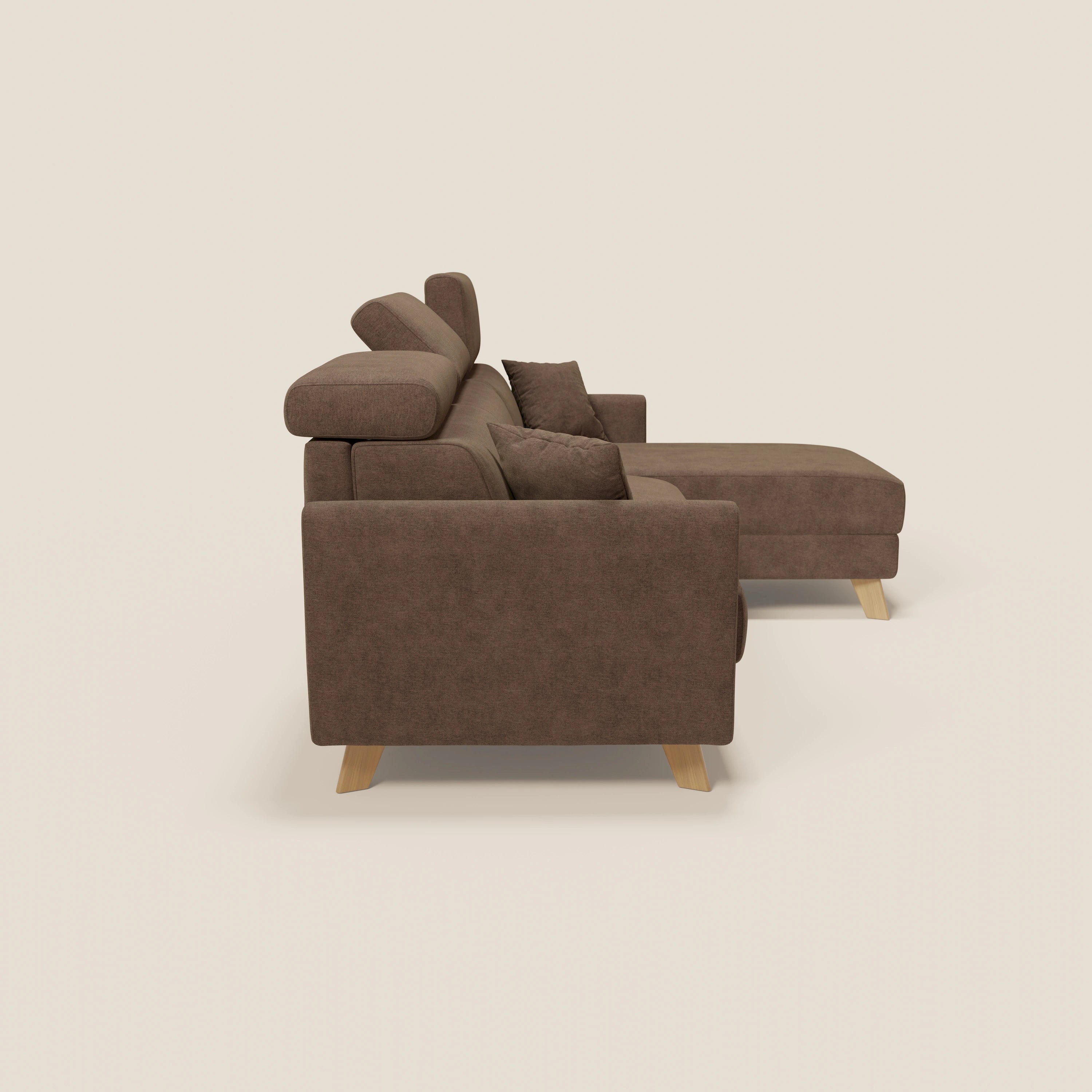 Un divano letto angolare Francy marrone di Divani.Store, sfoderabile, con chaise longue destra, poggiatesta regolabili e tessuto T17 antimacchia, è presentato lateralmente su sfondo beige con due cuscini a fantasia.