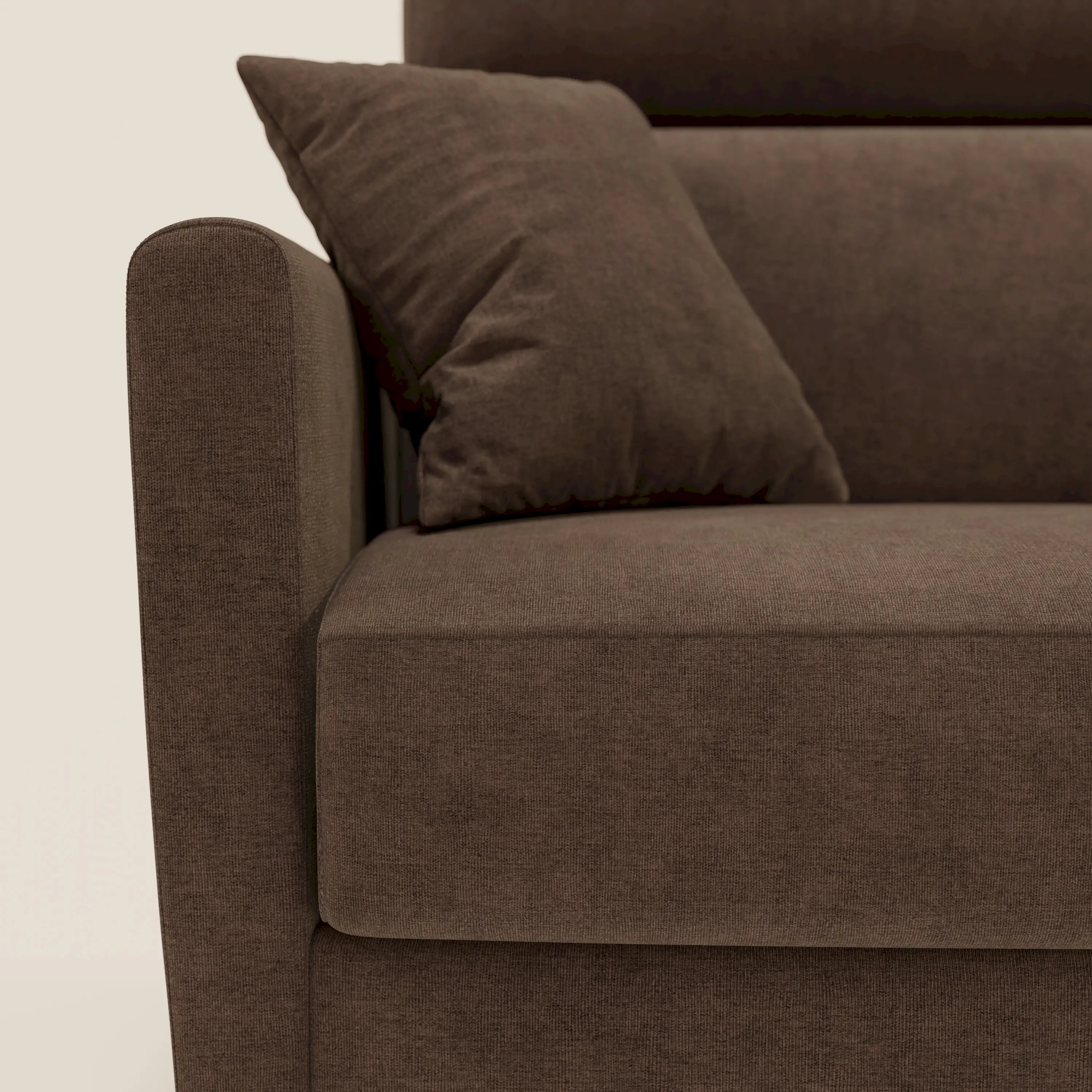 Primo piano del divano letto angolare sfoderabile Francy di Divani.Store in T17 marrone, che mostra il bracciolo sinistro, il cuscino di seduta e il cuscino coordinato. Lo sfondo bianco sporco ne evidenzia lo stile nordico, le linee pulite e la consistenza morbida.