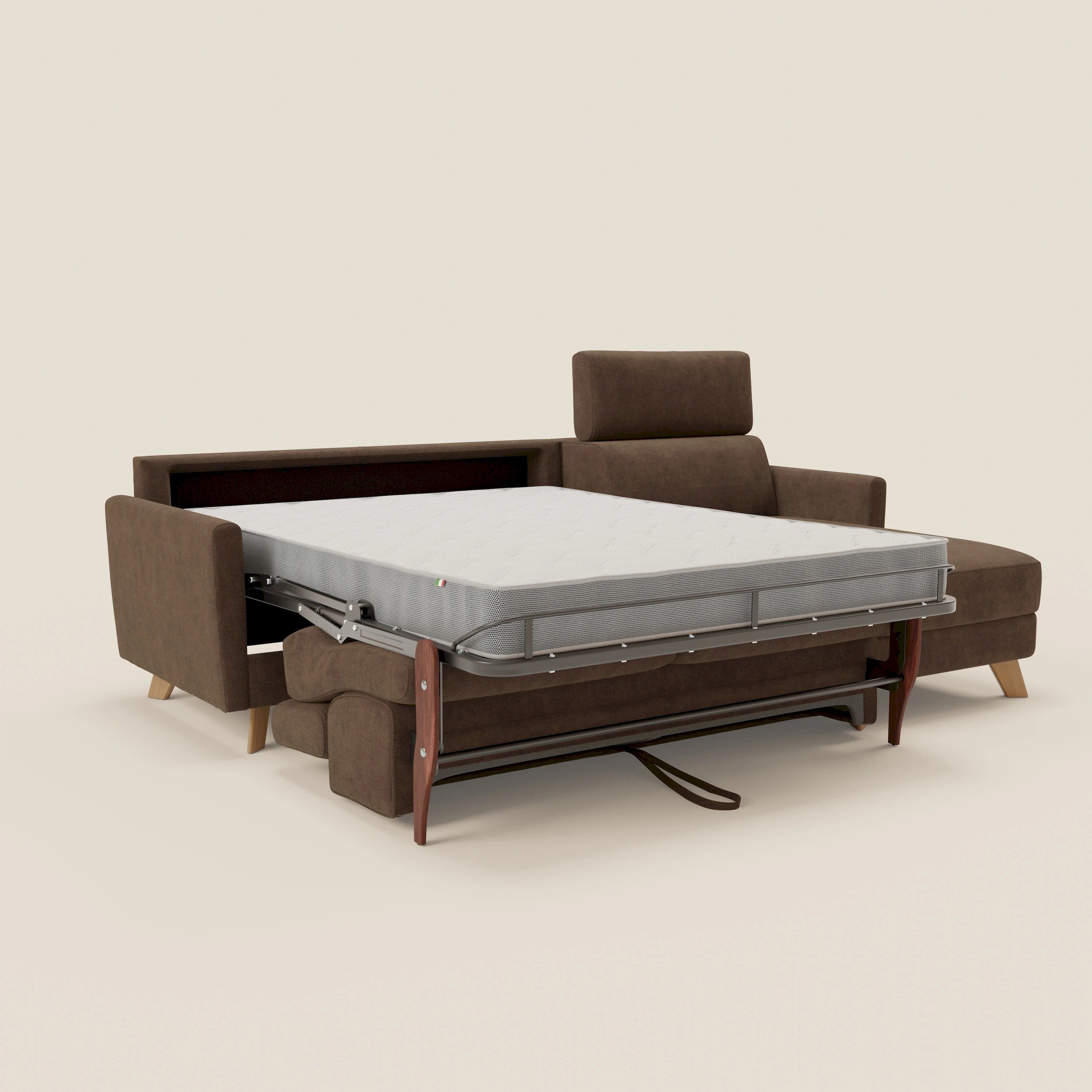 Il divano letto angolare sfoderabile Francy di Divani.Store in T17 marrone è esposto con il letto estraibile esteso, la struttura in metallo a vista e le gambe in legno. Il suo stile nordico risalta sullo sfondo beige chiaro.
