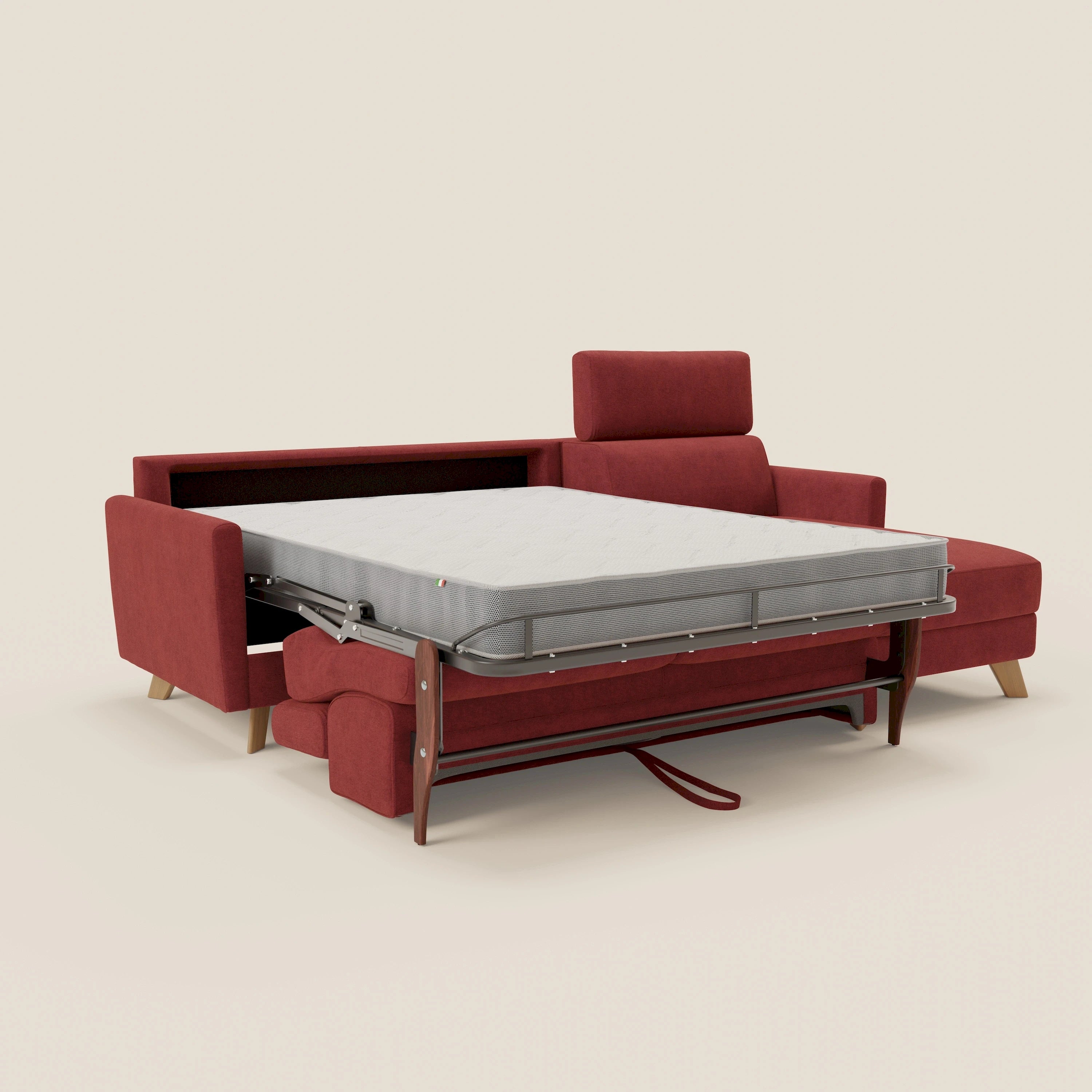 Il divano letto angolare sfoderabile Francy di Divani.Store in tessuto antimacchia rosso T17 è dotato di letto estraibile, chaise longue (penisola contenitore), poggiatesta reclinabili e gambe in legno. Su sfondo beige chiaro.