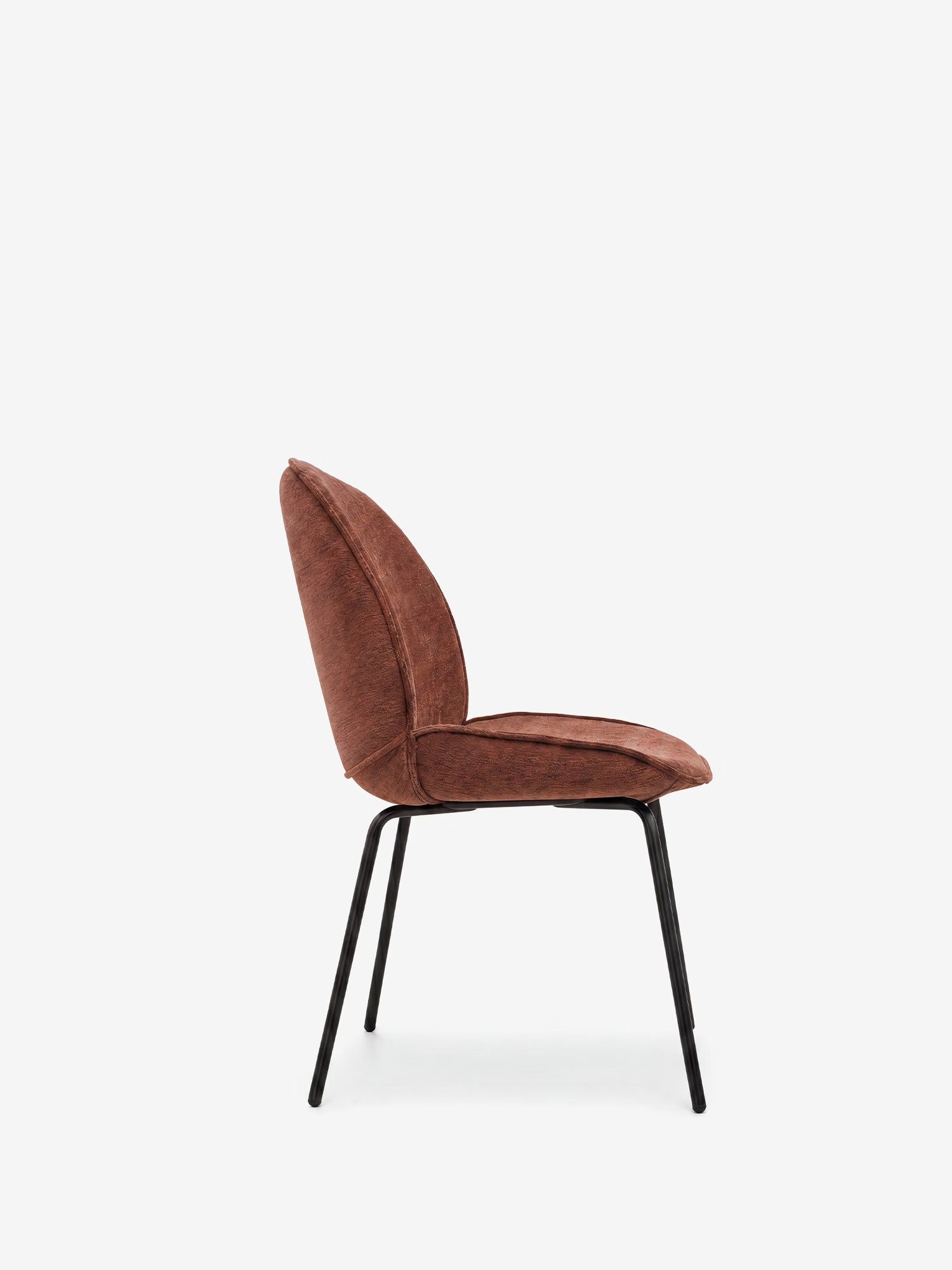 Una vista laterale della sedia Iride, imbottita in morbido tessuto materico di Divani.Store, mette in risalto la morbida seduta e lo schienale marroni, sostenuti da sottili gambe in metallo nero. Il design moderno e minimalista si caratterizza per le linee pulite che risaltano su uno sfondo bianco a tinta unita.