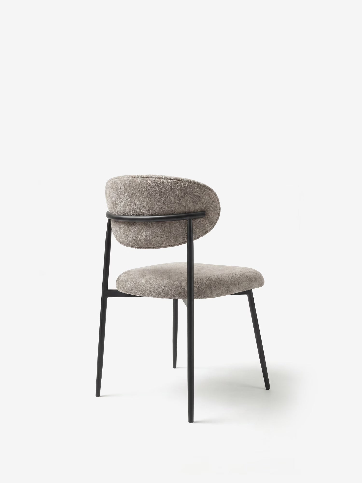 La Luce Sedia, imbottita in morbido tessuto ciniglia, di Divani.Store presenta uno schienale e una seduta arrotondati e imbottiti in ciniglia grigio chiaro, sottili gambe in metallo nero e un design minimalista e aperto, qui raffigurata su uno sfondo bianco.