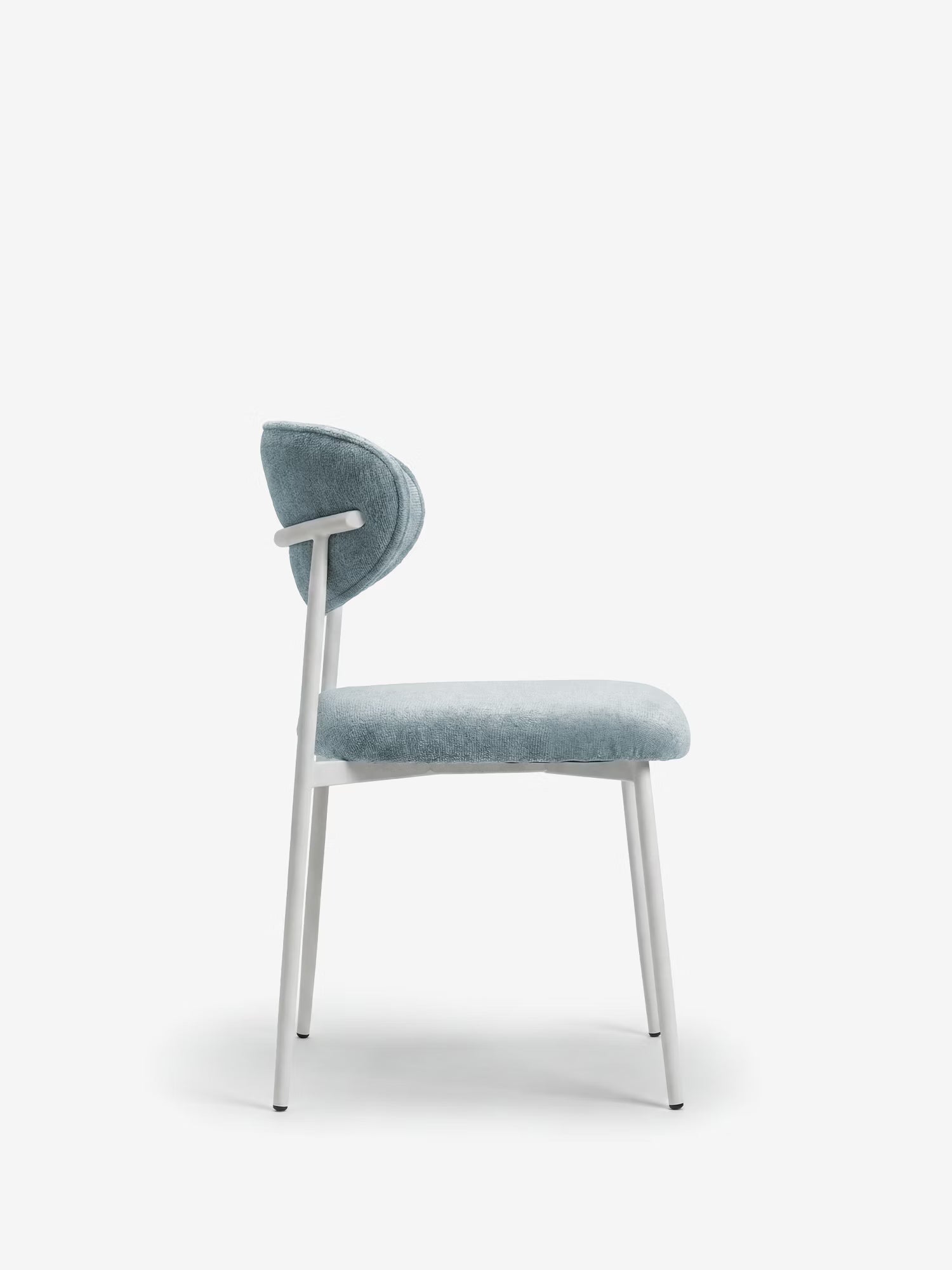 La Luce Sedia imbottita di Divani.Store presenta uno schienale curvo in tessuto e una seduta morbida, entrambi in ciniglia azzurra, con una struttura sottile in metallo bianco. Immagine del profilo laterale su sfondo bianco.