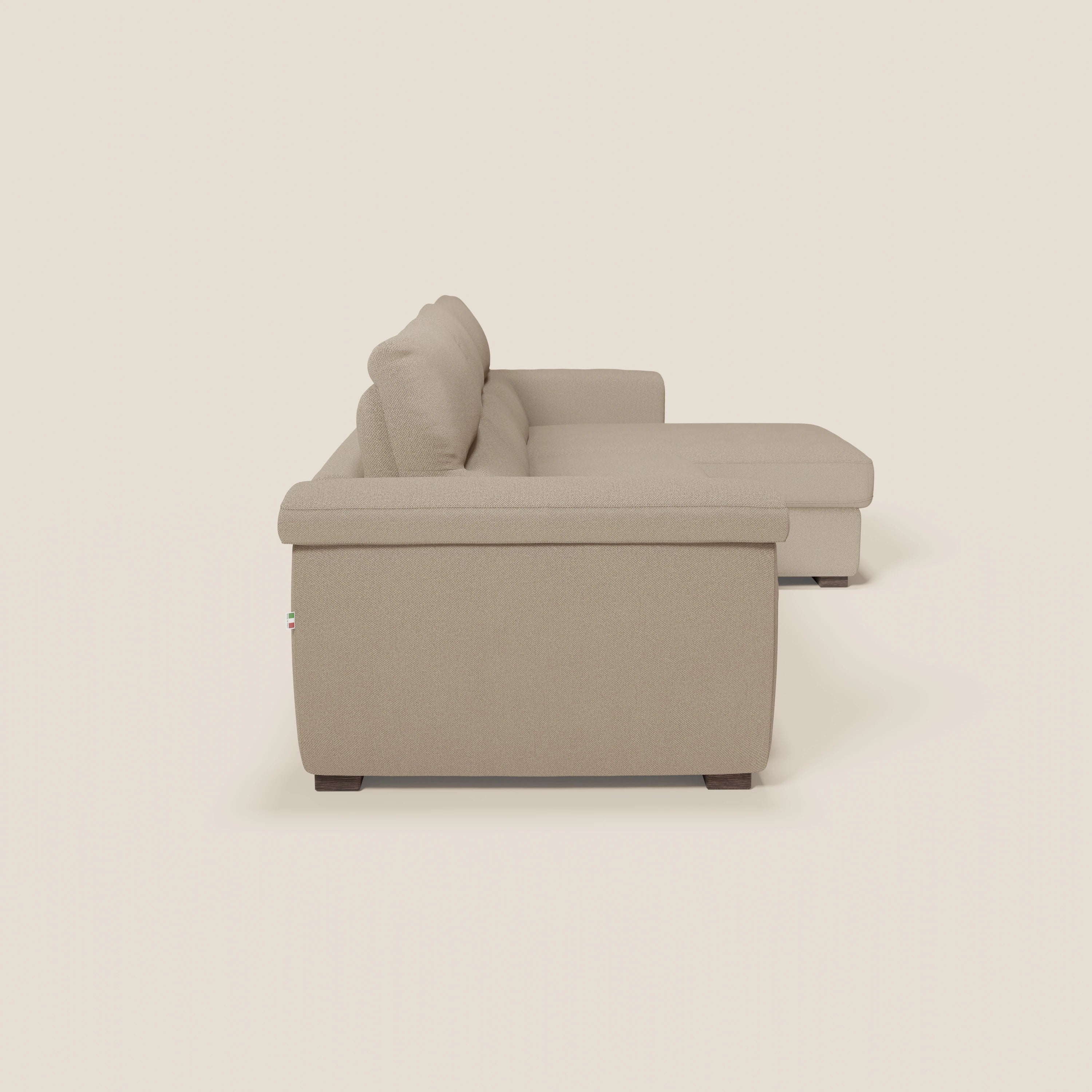 Il divano letto angolare Magnolia con penisola contenitore di Divani.Store, in tessuto smacchiabile T05 beige e materasso H18 cm, presenta un design minimalista, cuscini morbidi e gambe corte in legno scuro.
