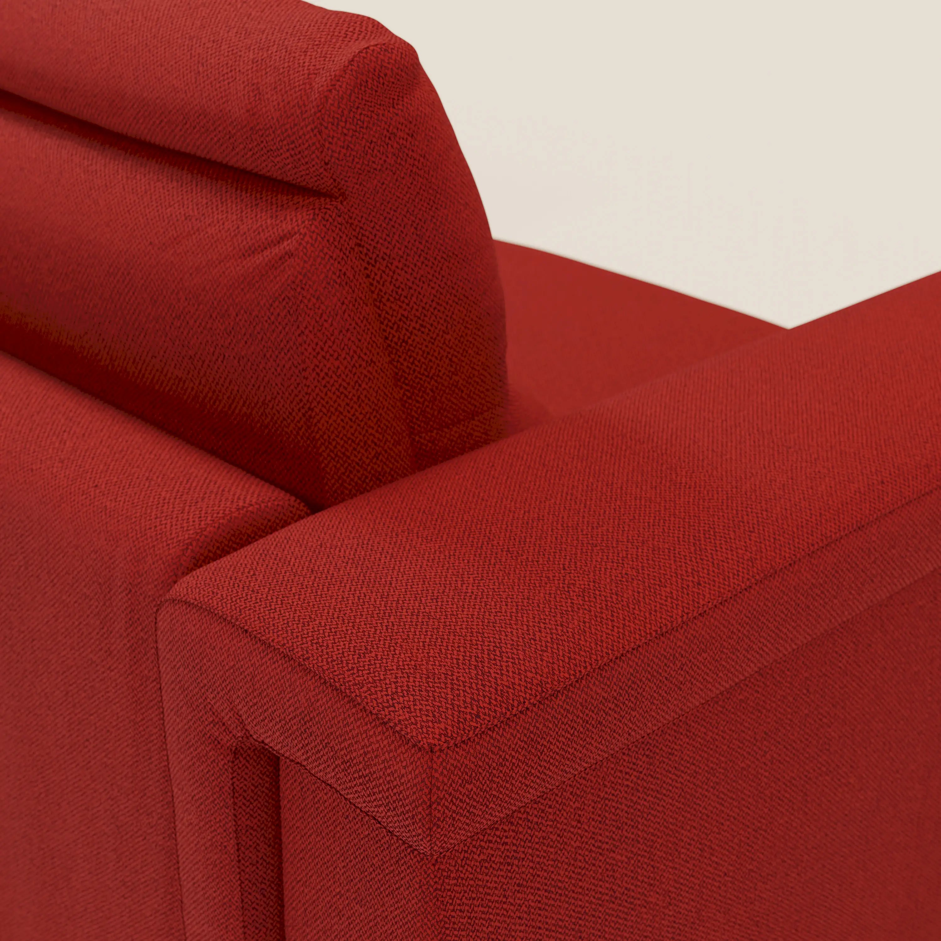 Primo piano dello schienale e del bracciolo del divano letto angolare Magnolia con Penisola Contenitore di Divani.Store in tessuto smacchiabile T05 rosso, che mette in risalto il rivestimento strutturato, le linee moderne e il profondo materasso comfort H18 cm.