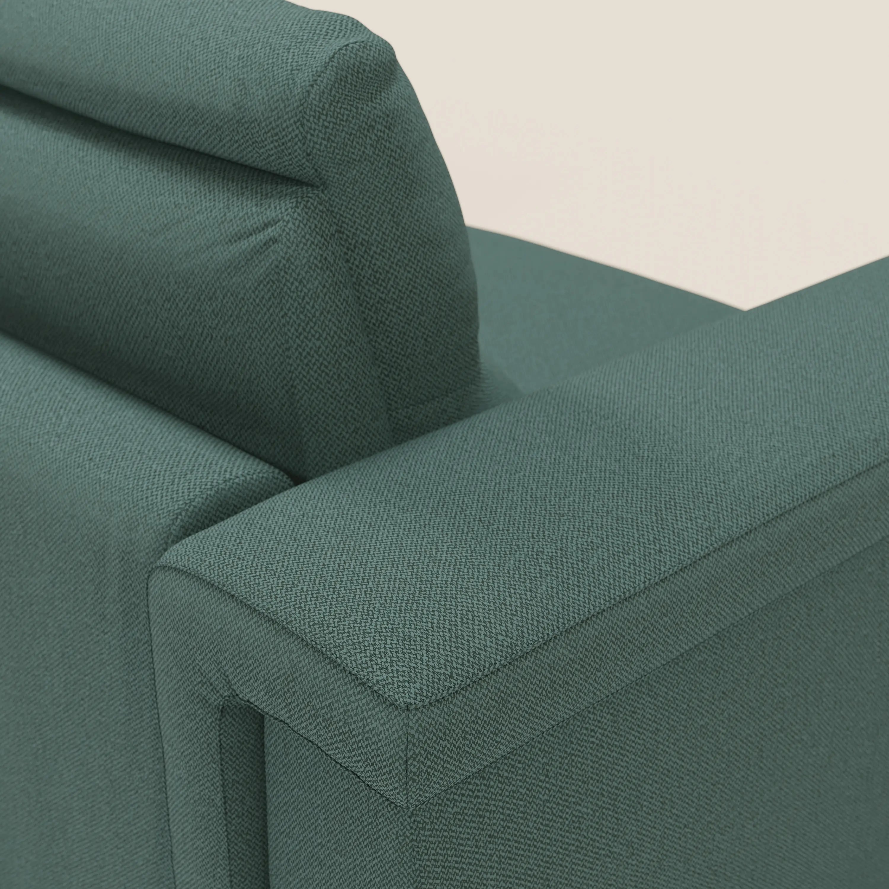 Primo piano dell'angolo superiore di Magnolia divano letto angolare con Penisola Contenitore di Divani.Store in tessuto smacchiabile T05 verde, che mostra il rivestimento testurizzato, il bracciolo, lo schienale e il poggiatesta su uno sfondo semplice.