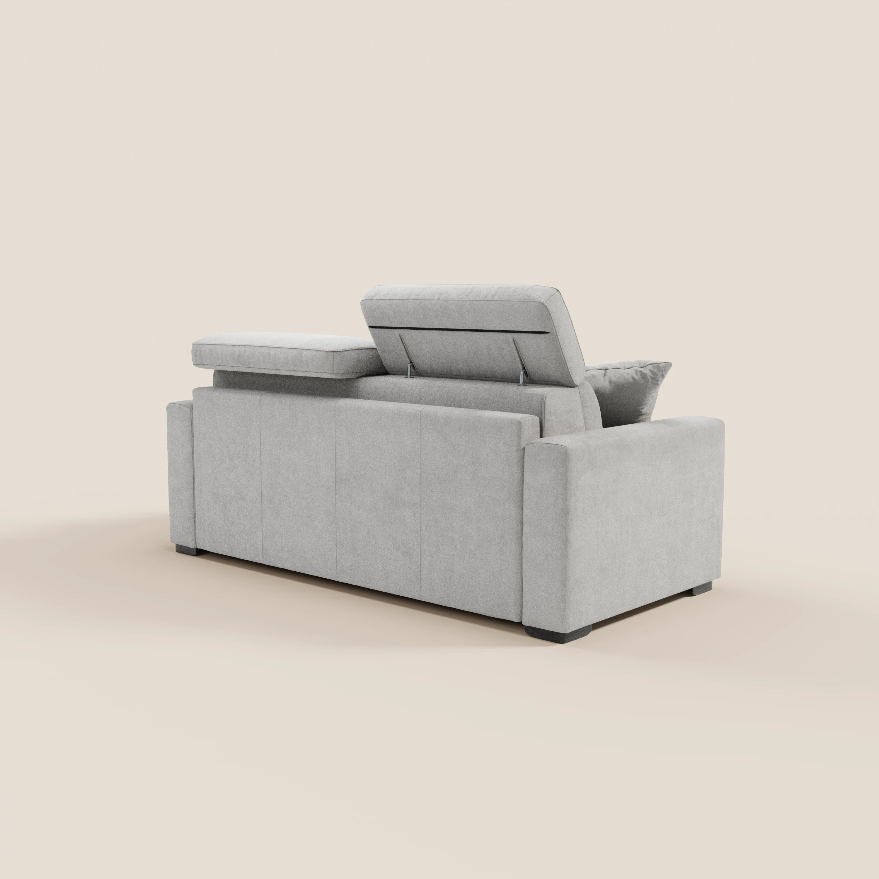 Il divano letto a 3 posti Maximus di Divani.Store è raffigurato di retro in grigio chiaro, con un poggiatesta reclinabile sollevato e uno in posizione orizzontale. Le linee pulite, gli ampi braccioli e i piedini neri bassi risaltano sullo sfondo chiaro e sobrio.