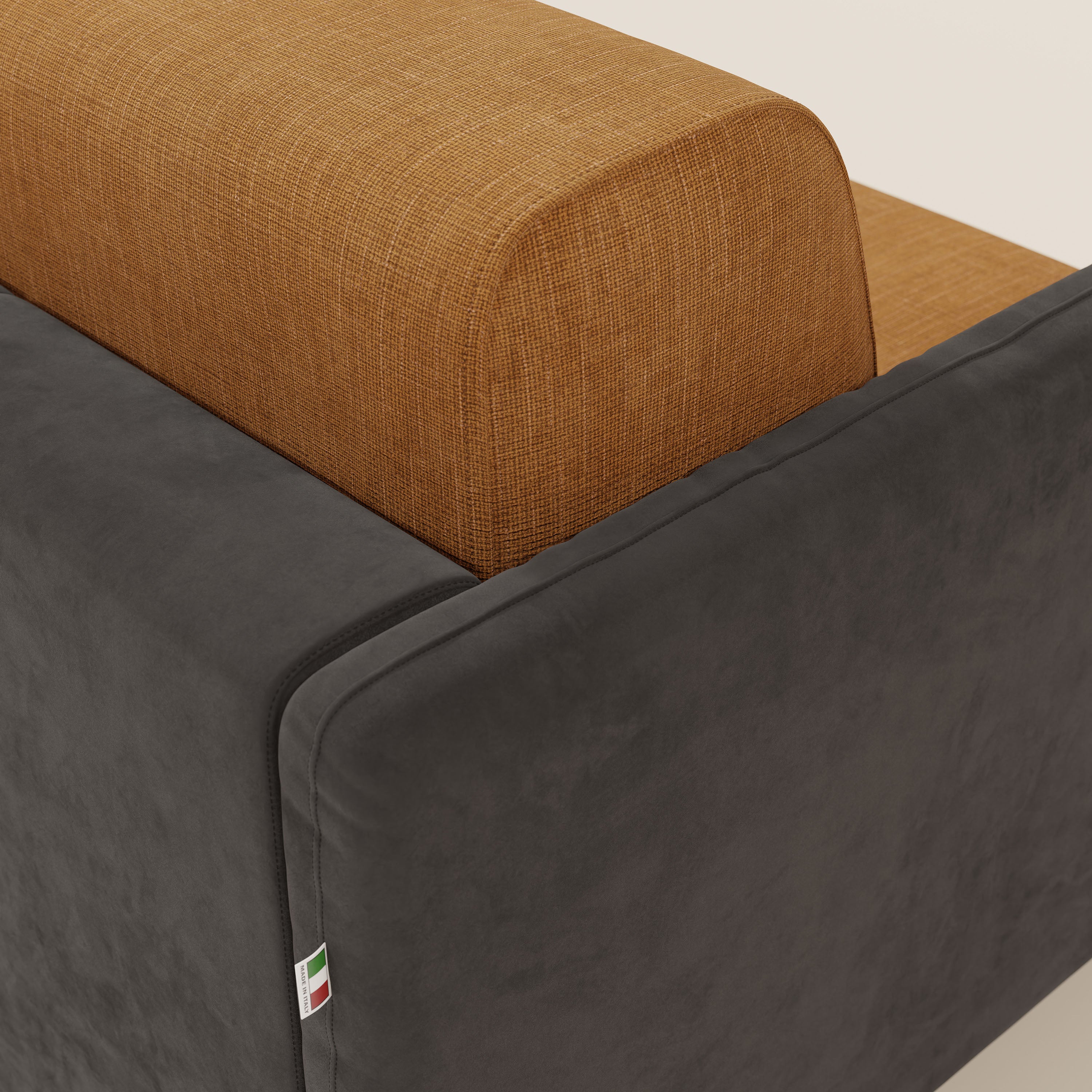 Primo piano del divano letto Narciso di Divani.Store: il materasso H18 cm e l'elegante tessuto impermeabile T06 nero-ocra, caratterizzato da schienale e seduta in microfibra testurizzata e braccioli lisci grigio scuro, oltre alla targhetta tricolore cucita.