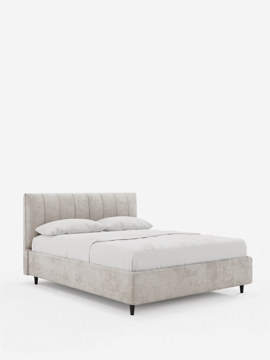 Il letto imbottito ONYX con contenitore e testiera verticale in tessuto certificato Oeko-Tex® è un letto beige con una testiera alta e cucita, biancheria da letto bianca e piccole gambe affusolate nere su uno sfondo chiaro e semplice.