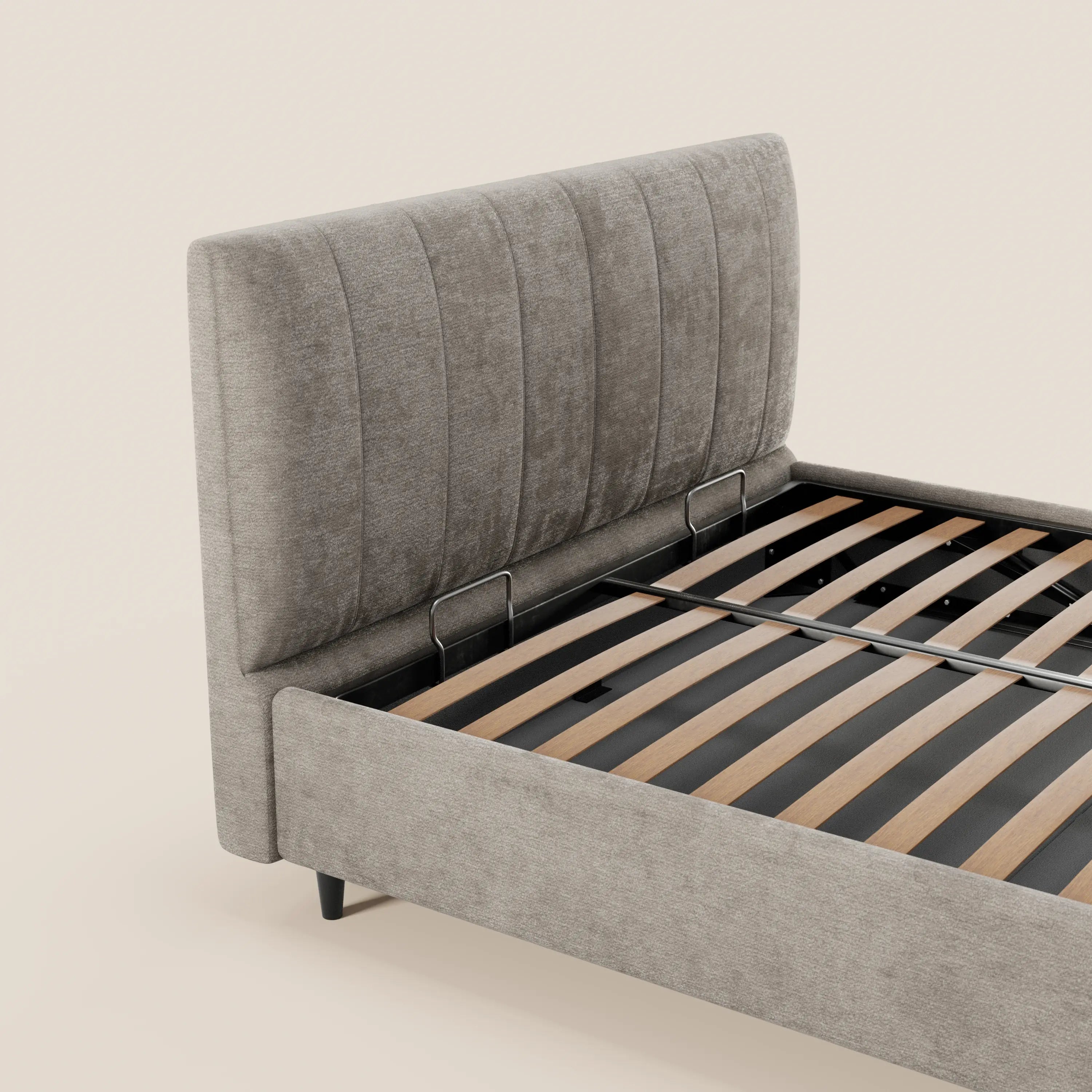 Il letto imbottito con contenitore ONYX di Letti.store è realizzato con un tessuto grigio chiaro certificato Oeko-Tex®, presenta una testiera alta con cuciture verticali, doghe in legno, guide in metallo e gambe corte nere su uno sfondo beige.