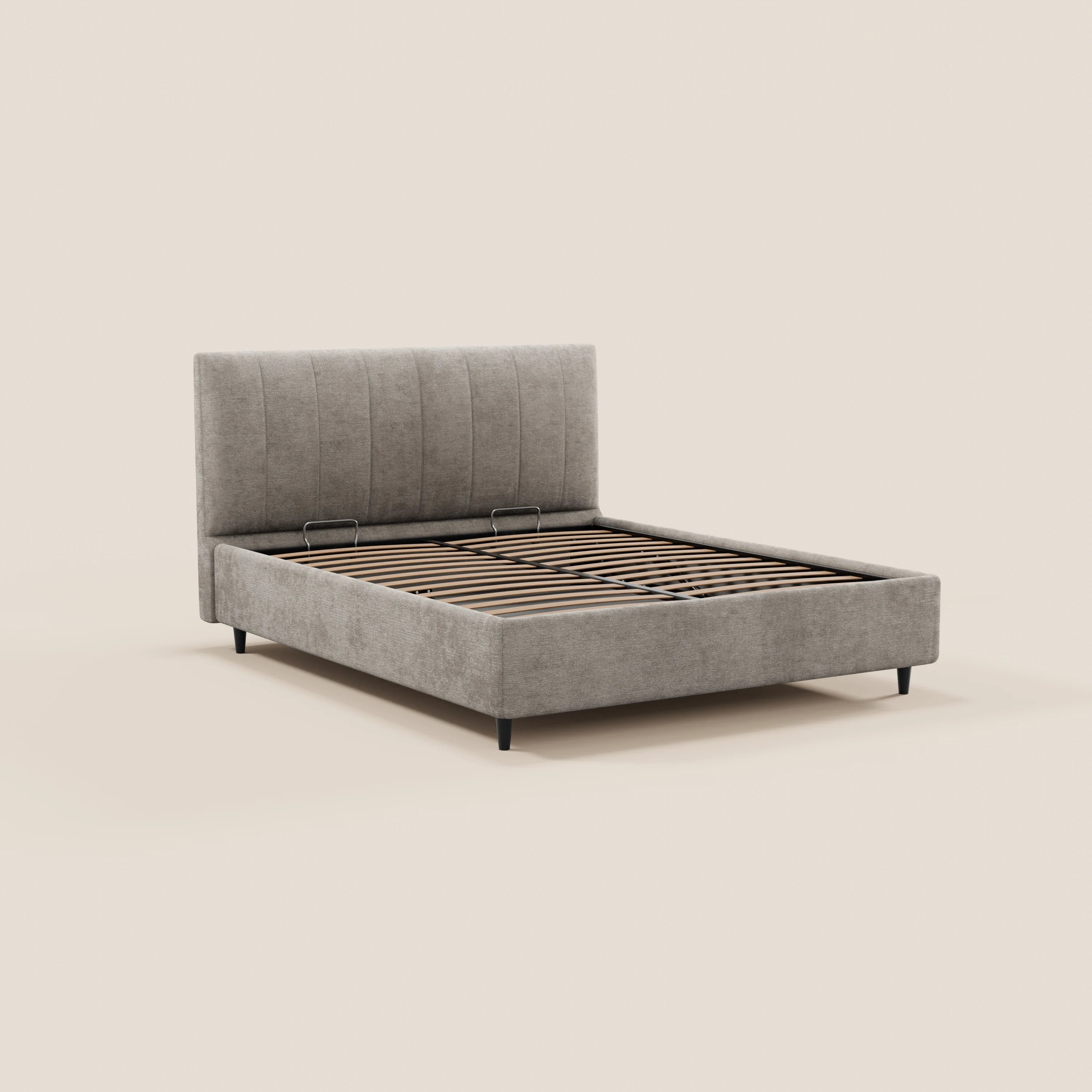 Il letto imbottito ONYX di Letti.store presenta una testiera alta in tessuto grigio chiaro con cuciture verticali, certificata Oeko-Tex®, doghe in legno, gambe corte nere e un vano contenitore integrato. Nell’immagine è raffigurato senza materasso né biancheria da letto su uno sfondo beige.