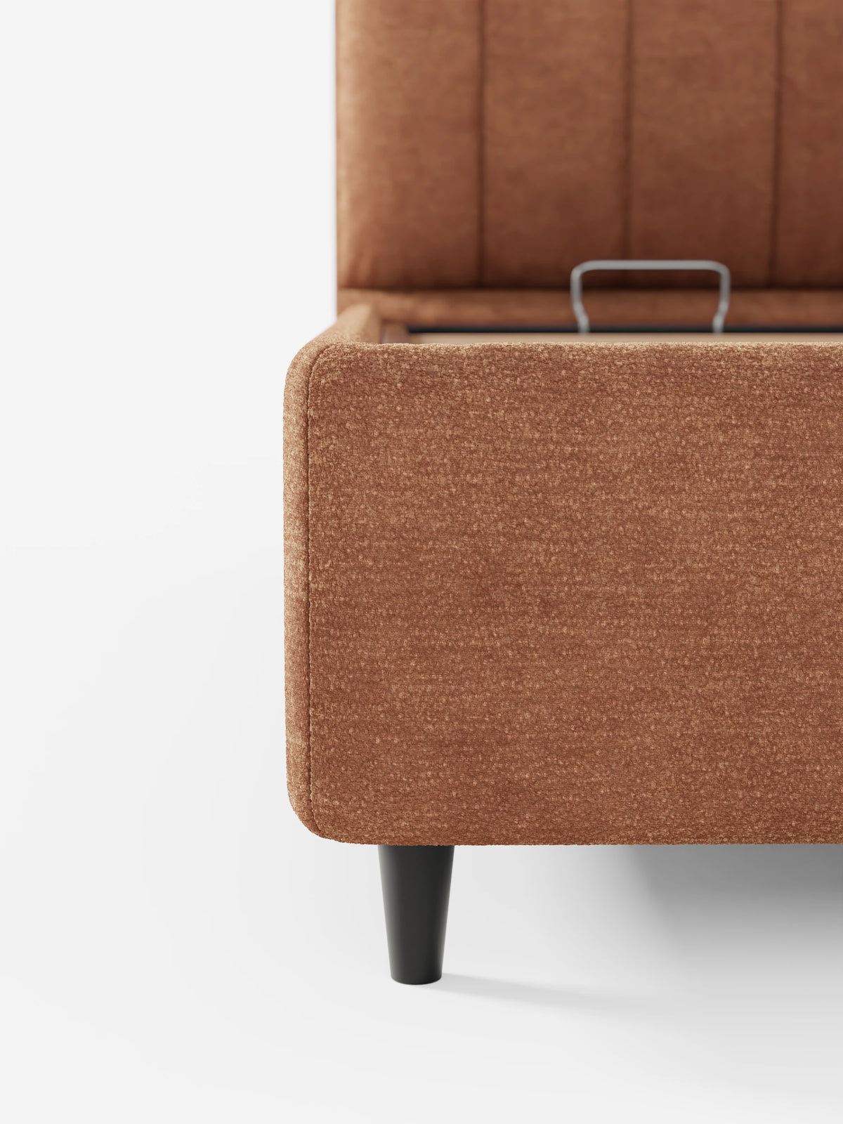 Un letto imbottito ONYX con vano contenitore e testiera verticale in tessuto certificato Oeko-Tex® color ruggine, caratterizzato da una testiera alta a pannelli, gambe affusolate scure e una base rialzata che rivela un vano contenitore.